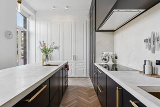 Cette maison de commerce pleine de caractère a été entièrement rénovée selon les normes contemporaines et finie avec des matériaux de haute qualité. Elle est située au bout d'une impasse, à distance de marche du marché de Geel. Toutes les commodités se trouvent à proximité, des magasins, des écoles, des transports en commun, des terrains de sport et des restaurants. Cette maison de maître au charme indéniable a été construite dans les années 1900, rénovée en 2013, 2017 et 2018. La propriété a une belle surface habitable d'environ 704 m².<br /><br />Rez-de-chaussée<br />Le rez-de-chaussée est organisé autour du hall d'entrée avec toilettes pour invités et vestiaire. Les deux espaces commerciaux ou de bureau se trouvent à l'avant de la maison et peuvent être aménagés ou modifiés selon vos souhaits. En outre, au rez-de-chaussée, on trouve une cuisine entièrement équipée avec une salle à manger spacieuse et un salon. Depuis la cuisine, on accède à une belle terrasse aménagée avec un étang.<br /><br />Étages<br />Le premier étage abrite un espace polyvalent actuellement aménagé en deuxième salon avec cuisine attenante. Vous pourrez également profiter de la terrasse avec vue sur le domaine du parc. La suite parentale, un dressing, une buanderie avec salle de bains attenante et des toilettes séparées. La grande salle de bains est équipée d'une baignoire, d'une grande douche à l'italienne, d'un lavabo, de toilettes et d'un bidet. Au deuxième étage, vous trouverez quatre chambres, deux salles de bains et des toilettes séparées. Il y a également une belle terrasse ensoleillée à cet étage. Enfin, le dernier niveau offre une grande chambre et un espace de rangement.<br /><br />Cave<br />La maison dispose d'une grande cave. La cave est aménagée comme suit : espace de détente, espace de rangement, buanderie avec chute à linge et local à vélos. La cave donne également accès à l'entrée latérale et au garage double intégré avec atelier.<br /><br />Particularités :<br />- Possibilités d'espace commercial ou de bureau<br />- Maison économe en énergie, certificat PEB A<br />- Chauffage au sol<br />- Système d'aspiration central<br />- Garage double intégré avec atelier<br />- Placards intégrés dans toute la maison<br />- Matériaux de haute qualité<br />- Caractère unique<br />- Station de recharge pour voiture électrique<br />Idéal pour combiner habitation et activité professionnelle !