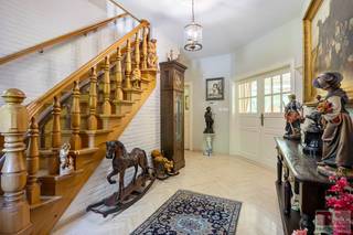 Ruime vrijstaande villa gebouwd in 1989, gelegen op een royaal perceel van 3049m² met een woonoppervlakte van 365m², deze karaktervolle villa ademt charme, klasse en ruimte. Met zijn kasteelachtige uitstraling en perfect onderhouden tuin straalt de woning van buitenaf pure elegantie uit. Binnen wacht een interieur dat even verzorgd is: een stijlvolle mix van klassieke elementen, warme materialen en een overvloed aan natuurlijk licht. De woonkamer is rijkelijk afgewerkt met sierlijsten, een statige haard en grote raampartijen met zicht op het groen. De keuken is volledig ingericht en sluit aan bij de huiselijke sfeer, terwijl de tuinkamer en het overdekte terras uitnodigen tot genieten in alle seizoenen. Op de verdieping bieden de slaapkamers volop ruimte met een grote bijhorende badkamer. Deze woning is ideaal voor wie op zoek is naar comfort, rust en een exclusieve uitstraling in een groene omgeving.<br /><br />Deze woning bevindt zich in een rustige en residentiële buurt, ideaal voor wie comfort en sereniteit zoekt. Op wandelafstand liggen scholen, supermarkten en ambachtelijke bakkers, wat het dagelijkse leven vergemakkelijkt. De nabijheid van het Nationaal Park Hoge Kempen biedt volop mogelijkheden voor wandel- en fietstochten in de natuur. Ook het winkelcentrum M2 en Maasmechelen Village zijn vlot bereikbaar met de auto. De E314 ligt in de directe omgeving, wat zorgt voor een snelle verbinding naar Genk, Hasselt en Nederland. Openbaar vervoer is eveneens goed toegankelijk. Hier woon je op een plek waar rust, natuur en bereikbaarheid perfect samenkomen.<br /><br />Bezichtig deze woning ook digitaal en 'loop' zelf door de woning. Kijk daarvoor op onze website of via: <br />my.matterport.com/show/?m=FqE5Ua9ZWBc<br /><br />INDELING<br /><br />Gelijkvloers:<br /><br />- Inkomhal met een houten trap vervaardigd uit Olmenhout (een bijzondere houtsoort), uitgerust met een alarmsysteem en parlofoon;<br />- Woonkamer afgewerkt met een travertijnvloer, een gashaard met afstandsbediening (Barabas), coax-aansluiting voor televisie en granieten vensterbanken in het hele vertrek;<br />- Volledig ingerichte keuken met een keramische kookplaat (4-pits Miele), vaatwasser, combi-magnetron (AEG), afzuigkap en een friteuse combi-set (Miele);<br />- Praktische, betegelde bijkeuken met aansluitingen voor wasmachine, spoel- en afgietbak, maatwerkkasten en verwarming;<br />- Lichtrijke tuinkamer (met airco) die alle comfort biedt om het hele jaar door van de tuin te genieten;<br />- Gastentoilet (Geberit) met arduinen lavabo.<br /><br />1e verdieping: <br /><br />- Slaapkamer 1 is afgewerkt met een parketvloer en beschikt over een ensuite dressing met maatwerkkasten;<br />- Badkamer met inloopdouche, dubbele wastafel met spiegelkast, toilet (Sphinx), bidet (Frederich Gröhe), ligbad met jets en thermostatische kraan, elektrische handdoekradiator en tegelvloer;<br />- Slaapkamer 2, gelegen aan de voorzijde onder de toren, beschikt over een bergzolder en is afgewerkt met een vloerkleed;<br />- Slaapkamer 3 is zeer lichtrijk en voorzien van een houten vloer;<br />- Slaapkamer 4, aan de achterzijde van de woning, beschikt over ingebouwde wandkasten op maat;<br />- Alle ramen op de bovenverdieping zijn voorzien van een alarmsysteem.<br /><br />Zolder:<br /><br />- Ruime zolder voorzien van CV ketel met bijhorende technieken (Buderus Logalux S160, Buderus Logamax plus GB162-45BE en bijhorend expansievat).<br /><br />Kelder:<br /><br />- Grote kelder die volledig betegeld werd, ideaal als hobbyruimte met eigen invullen, voorzien van verwarming, systeemplafond en kruipruimte.<br /> <br />Tuin:<br /><br />- Zuidwest georiënteerde tuin;<br />- Arduinen terras met overkapping;<br />- Vijver met siervissen en houten brugje;<br />- 26 zonnepanelen van ieder 305 watt;<br />- Buitenkraan met grondwaterpomp, tevens werd er ook een irrigatiesysteem geïnstalleerd met volautomatisch systeem (Rainbird computer);<br />- Tuinhuis met elektriciteit, water en afvoer;<br />- Fruitbomen (perzik, kersen, peren en appel);<br />- Grote kasseien oprijlaan, tevens voorzien van sierhekwerk met afstandsbediening.<br /><br />Bijzonderheden:<br /><br />- Voor de ramen werd gebruikgemaakt van de duurzame en exclusieve houtsoort Marbou;<br />- 2 septische putten, voorzieningen voor riolering zijn reeds getroffen;<br />- De leien zijn Spaanse natuurleien van 1989;<br />- Elektrische screens in de tuinkamer;<br />- De buitenmuren zijn uitgevoerd met  2 spouwen met er tussen een isolatie steen, totale dikte   34  cm;<br />- De binnenste spouw is voorzien van lagen folie om de meter zodat de lucht blijft stilstaan (hogere isolatie  waarde);<br />- De woonkamer is evenals  keuken en tuinkamer voorzien van vloerverwarming als basis verwarming met tevens  radiatoren als  aanvulling;<br />- Daarnaast is de woonkomen voorzien van afzuig systeem hetwelk in de zomermaanden kan dienen voor topkoeling.<br /><br />Energieprestatie en binnenklimaat (EPB-EPC)<br />Certificaat beschikbaar: Ja<br />EPC certificaatnummer: 20250318-0003554918-RES-1<br />Berekende energiescore : (kWh/m²):  215 (label C)<br />Het certificaat is geldig tot en met: 18/03/2035<br />Electrische installatie: in aanvraag<br /><br />Informatie stedenbouwkundige voorschriften:<br />Stedenbouwkundige vergunning: in aanvraag<br />Meest recente bestemming: woonpark<br />Dagvaarding uitgebracht: in aanvraag<br />VOORKOOPRECHT OP DIT GOED: neen <br />VERKAVELINGSVERGUNNING: neen<br />WATERGEVOELIG OPENRUIMTEGEBIED: neen<br /><br />Overstromingsgevoelige gebieden: <br />Perceelscore of P-score : A<br />Gebouwenscore of G-score: A<br />Ligging in Signaalgebied: neen<br />Ligging in afgebakende oeverzone of afgebakend overstromingsgebied: neen<br /><br />A:geen overstroming gemodelleerd B: kleine kans op overstromingen onder klimaatverandering C: kleine kans op overstromingen D: middelgrote kans op overstromingen<br /><br />Beschermd erfgoed<br />GEINVENTARISEERD ERFGOED: neen<br />BESCHERMD ONROEREND ERFGOED: neen