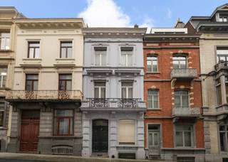 <p><strong>BRUSSEL Centrum</strong> – Achter haar karaktervolle gevel onthult deze Brusselse woning uit 1890 een authentieke sfeer en een zeldzaam potentieel. Gelegen in het hart van de Libertés-wijk, op een steenworp van het Barricadenplein, geniet zij van een centrale en gegeerde ligging, terwijl ze tegelijk rust biedt dankzij een discrete straat.<br />De royale volumes, de mooie plafondhoogtes en de verdeling over meerdere niveaus vormen een ideaal canvas voor een ambitieus en volledig op maat gemaakt renovatieproject. Gezellige leefruimtes, comfortabele slaapkamers, bureaus en polyvalente ruimtes: elke verdieping opent nieuwe mogelijkheden en nodigt uit om de woning opnieuw vorm te geven volgens uw wensen.<br />Achteraan verlengt een intieme binnenkoer de leefruimtes, terwijl de hogere verdiepingen nog tal van inrichtingsmogelijkheden bieden, zoals een master suite, een creatieve ruimte of een thuiskantoor. Kelders en zolder vervolledigen het geheel en versterken het potentieel van dit pand.<br />Deze woning richt zich tot liefhebbers van historische architectuur, creatieve geesten en renovatie-enthousiastelingen die een karaktervolle woning met geschiedenis nieuw leven willen inblazen, in het hart van Brussel.</p>
<p><strong>Tweegevelwoning gebouwd in 1890 van ± 245 m², te renoveren</strong></p>
<p><strong>Kelderverdieping:</strong><br />Kelders van ± 40 m²</p>
<p><strong>Gelijkvloers:</strong> ± 72 m²<br />Inkomhal – Woon-/eetkamer – Half ingerichte keuken – Koer van ± 5 m²</p>
<p><strong>1e tussenverdieping:</strong><br />Toilet met handwasbakje</p>
<p><strong>1e verdieping:</strong> ± 60 m²<br />Slaapkamer 1 van ± 20 m² met balkon van ± 2 m² –<br />Slaapkamer 2 van ± 16 m² –<br />Bureau van ± 8 m² –<br />Badkamer</p>
<p><strong>2e tussenverdieping:</strong> ± 5 m²<br />Toilet en berging</p>
<p><strong>2e verdieping:</strong> ± 60 m²<br />Slaapkamer 3 van ± 20 m² –<br />Slaapkamer van ± 18 m² –<br />Dressing van ± 8 m² –<br />Doucheruimte</p>
<p><strong>3e verdieping:</strong> ± 40 m²<br />Ruimte van ± 16 m² met toegang tot een platform van ± 15 m² –<br />Ruimte van ± 8 m² –<br />Bureau van ± 8 m²</p>
<p><strong>Zolder:</strong> ± 25 m²</p>
