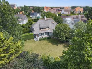 Deze authentieke villa bevindt zich in de exclusieve Simli wijk te Nieuwpoort-Bad, op wandelafstand van het strand, de vaargeul en de jachthaven.<br />De villa beschikt over een statige inkomhal met gastentoilet en een imposante trappenhal. De ruime en lichtrijke woonkamer met authentieke open haard sluit naadloos aan op de veranda, waarin zich de volledig ingerichte keuken met gezellige eetruimte bevindt met toegang tot het zonneterras en aangelegde tuin. Verder beschikt het gelijkvloers over een praktische wasplaats en een ruime bureauruimte, die ingericht kan worden als extra slaapkamer.<br />Op de verdieping bevinden zich vier volwaardige slaapkamers. De masterbedroom beschikt over een en-suite badkamer, uitgerust met een bubbelbad, inloopdouche, dubbele wastafel en toilet. De drie overige slaapkamers zijn elk voorzien van een eigen douche en wastafel. Daarnaast bevindt zich op de nachthal nog een afzonderlijk toilet. De ruime zolder biedt bovendien extra bergruimte.<br />Het ondergrondse niveau beschikt over een uitzonderlijk ruime inpandige garage met plaats voor drie wagens, diverse bergingen en een wijnkelder, een absolute meerwaarde voor de liefhebber of verzamelaar.<br />De unieke combinatie van ruimte, karakter, comfort en een absolute topligging maakt van deze villa een uitzonderlijk aanbod in Nieuwpoort.