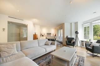 <p>Dit instapklare appartement op de eerste verdieping combineert ruimte, comfort en een hoogwaardige afwerking. <br />Via de inkomhal met vestiairekast bereikt u de lichtrijke leefruimte 30 m² op parket, voorzien van een stijlvolle boekenkast met geïntegreerde verlichting. <br />Aansluitend bevindt zich de volledig geïnstalleerde open keuken 15 m² met kwalitatieve Miele-toestellen en een composieten werkblad. <br />Vanuit de keuken heeft u via een schuifraam met vliegenraam toegang tot het overdekte terras.<br /><br />De nachthal geeft toegang tot een apart gastentoilet en de slaapvertrekken. <br />De ruime masterbedroom 30 m² beschikt over een dressing met maatwerkkasten en een ensuite badkamer met dubbele lavabo, inloopdouche, toilet en handdoekdroger. <br />De tweede slaapkamer 18 m² heeft eveneens een eigen douchekamer met lavabo.<br /><br />Verder beschikt het appartement over een praktische berging 5 m² met maatwerkkasten en aansluitingen voor wasmachine en droogkast, evenals een privatieve berging 7 m². Bij het appartement horen bovendien twee open autostaanplaatsen.<br /><br />BIJZONDERHEDEN<br />Vaste kosten 200 euro/maand.<br />Lift, vloerverwarming, CV op gas, Vaillant ketel, alarm, airco, rails voor kunst op te hangen, veiligheidsdeur.</p>