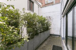 <p><strong>Bezoekaanvragen worden per mail behandeld. </strong></p>
<p>Achter de imposante gevel van deze 16de-eeuws geklasseerd gebouw, ontdek je dit trendy appartement met maar liefst 2 slaapkamers, gelegen in hartje Antwerpen tussen het Antwerpse Zuid en het Sint-Andrieskwartier.</p>
<p>Bij het binnenkomen word je meteen ondergedompeld in een unieke, Middeleeuwse sfeer die perfect evenaart aan de befaamde Vlaeykensgang dankzij de gemeenschappelijke hal en binnenkoer die werden belegd met authentieke steentjes.</p>
<p>Het appartement beschikt over een inkomhal met een gastentoilet volledig in marmer, een lichtrijke leefruimte met brede houten plancher vloeren en een prachtige open keuken met een werkblad in corian. Deze is voorzien van een keramische kookplaat, oven, ijskast met diepvriesvak, dampkap en vaatwasser.</p>
<p>De badkamer werd ondergedompeld in dezelfde marmer en heeft een ligbad, inloopdouche, sierradiator en een zwevend lavabomeubel met dubbele lavabo.</p>
<p>Een charmante stadstuin vervolledigt dit appartement.</p>
<p><strong>Geen co-housing, geen korte termijn verhuur.<br />Beschikbaar vanaf 1 september 2026.</strong></p>
<p><strong>Maandelijkse kosten: </strong>slechts € 25,00 (licht in de hal & schoonmaak gemene delen).</p>
<p>Technische gegevens: Alle nutsvoorzieningen CV (gas), elektriciteit en water zijn <strong>individueel</strong>. HR combiné warm water 24KW, dubbele beglazing met een houten omkadering. <strong>Fietsenstalling</strong> aanwezig.</p>