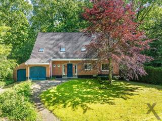 Gelegen op een idyllisch perceel van maar liefst 2.224 m², verscholen in het weelderige en rustgevende groen, presenteren wij deze royale vrijstaande villa. Met een bewoonbare oppervlakte van circa 230 m² en een bosrijke tuin biedt dit eigendom een zeldzame basis voor wie op zoek is naar ultieme rust, privacy en de unieke kans om een droomwoning volledig naar eigen hand te zetten. De statige architectuur met de warme rode baksteen en de omringende volwassen bomen zorgen bij aankomst direct voor een warm en exclusief gevoel.
De binnenzijde van de villa kenmerkt zich door een uiterst doordachte indeling met een zee aan ruimte. Op het gelijkvloers bevindt zich, naast de keuken en leefruimte met prachtig zicht op de omliggende natuur, een praktische kantoorruimte. Deze kamer leent zich uitstekend als thuiswerkplek of als volwaardige extra slaapkamer op de begane grond. Op de bovenverdieping biedt de woning ruimte aan vier comfortabele, volwaardige slaapkamers, waardoor het pand perfect beantwoordt aan de noden van een groot gezin.
Een absolute en unieke troef van dit vastgoed is de riante aanpalende werkplaats. Deze multifunctionele ruimte biedt tal van architectonische en professionele perspectieven. Dankzij de royale oppervlakte en de directe verbinding met het hoofdgebouw transformsert u deze zone moeiteloos tot een high-end praktijk voor een vrij beroep, een inspirerend kunstenaarsatelier, of een stijlvol thuiskantoor met eventueel een aparte toegang voor cliënten.
De woning beschikt momenteel over een EPC-score F, wat een renovatieverplichting met zich meebrengt. Dit is echter de uitgelezen kans voor de meerwaardezoeker. De solide constructie en de royale volumes nodigen uit om deze villa te moderniseren naar de allerhoogste hedendaagse normen van luxe, comfort en energie-efficiëntie. Met de juiste visie transformeert u dit object in een ecologisch en esthetisch meesterwerk. Laat u betoveren door de ongekende potentie en de magnifieke groene setting van deze villa en maak van dit project uw eigen exclusieve parel.