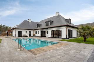 Bent u op zoek naar een RUIME en ruim ingedeelde instapklare luxe villa met ook nog eens veel buitenruimte en een grote garage / bijgebouw? En zelfs nog een zwembad 🏊 en de mogelijkheid tot kangoeroewoonst? Hier is het allemaal. Deze woning heeft een bewoonbare oppervlakte van ca 350 m2 en is gelegen op een mooi breed zuidgericht perceel van 2451 m². De ligging is TOP: rustig, residentieel en vlakbij natuurgebieden. Het bijgebouw / de grote garage biedt plaats voor 3 auto's en op het terrein is plaats zat voor uw mobilhome, camionette(s).... Deze luxe villa is zeer degelijk afgewerkt. De eerste eigenaar was dan ook schrijnwerker en dat merk je door heel de woning: degelijke houten vloeren, trap, enorm veel inbouwkasten, ramen, deuren, keuken: alles topkwaliteit. De woning is perfect gelijkvloers te bewonen doordat er twee slaapkamers en een badkamer zijn. Ook lenen de kamers zich perfect om jouw zelfstandig beroep / bijberoep uit te oefenen: kapsalon, schoonheidssalon, kantoor, ...Er is een aparte zij-ingang: ideaal om uw klanten te ontvangen of als tweede, aparte toegang tot de bovenverdieping.Er is tevens een kantoorruimte met toegang via de inkomhal vooraan.De verdieping is een enorme extra: hier zijn zoveel mogelijkheden: er zijn 3 slaapkamers en een grote polyvalente ruimte met keukenblok en badkamer: dan denk je direct aan co-housen, kangoeroewonen, ruimte voor logées, hobbyruimte, etcMogelijkheden genoeg! Bekijk ook zeker de plannen met volledige indeling en de video op onze site! Maak snel jouw afspraak voor dit unieke pand!
