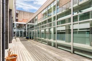 <p>Tussen het nieuwe Zuidpark en het pas gerenoveerde KMSKA, en dus hartje Zuid, vinden we dit uitzonderlijke kantoor terug. Met een gevelbreedte van zo’n 40 meter en een totale oppervlakte van ca 800 m² is dit pand zondermeer uitzonderlijk te noemen.</p>
<p>In de Museumstraat, met de Delhaize, The Butcher’s store, en bakkerij Dellafaille is dit dé topstraat van het Zuid. Een mooie visibiliteit en dus het perfecte uithangbord voor uw kantoor. Ook logistiek bent u zo de Stad uit dankzij de nabijheid van verschillende invalswegen.</p>
<p>Het pand is zowel toegankelijk via de straatzijde als via een binnengebied en verdeeld over twee plateau, beide toegankelijk via trap en lift voor een flexibele toegankelijkheid.</p>
<p>Meterslange glaspartijen, van vloer tot plafond, zowel langs het binnengebied als langs de Museumstraat, laten elke ruimte baden in het natuurlijk licht.</p>
<p>Via de hoofdinkom langs het binnengebied, heeft u achteraan toegang tot een zeer ruime vergaderzaal met aansluitend een polyvalente ruimte met een bar. De authentieke bakstenen gevelsteen werd zichtbaar gehouden om de ruimte net een extra touch te geven. Mat glas en schuifdeuren bieden de mogelijkheid om het geheel open te houden, dan wel af te sluiten voor confidentiële vergaderingen.</p>
<p>Via de centrale trap bereikt u het onthaal met balie op de eerste verdieping. Centraal gelegen tussen de voorbouw met in totaal acht afgesloten bureauruimtes en de achterbouw met één grote co-working space.</p>
<p>De doorlopende parketvloer in combinatie met zwarte fineereiken maatkasten zorgt voor een standingvol geheel dat elke huisstijl toelaat en een neutrale basis is om met te starten.</p>
<p>Gezien de grote oppervlakte werd er op verschillende plekken sanitair (in totaal 7 toiletten) en kitchenettes voorzien.</p>
<p>Zeven autostaanplaatsen in de ondergrondse garage kunnen bijgekocht worden aan 40.000 Euro per autostaanplaats. Verder bieden de nieuwe betaalparkings "Kooldok" en "Steendok" extra parkeergelegenheid voor personeel of cliënteel.</p>