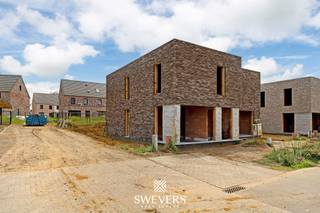 Voor meer info en foto’s, surf naar www.swevers.be – Ontdek deze stijlvolle halfopen nieuwbouwwoning in de Simone Reyndersstraat 13 (lot 21) in Heusden-Zolder. Met een bewoonbare oppervlakte van 144 m² combineert deze woning ruimte, comfort en een doordachte indeling. De lichtrijke leefruimte van 37,13 m² sluit naadloos aan op de volledig afgewerkte open keuken van 8,25 m². Bij een tijdige aankoop kunt u bovendien nog bepaalde materialen en afwerkingen mee kiezen. Via de leefruimte bereikt u het terras van 19,2 m², dat nog naar eigen smaak kan worden aangelegd. Dankzij de zuidoostelijke oriëntatie geniet u hier al vroeg van de zon. Op de verdieping bevinden zich drie ruime slaapkamers van 15,36 m², 12,15 m² en 10,80 m² en een volledig afgewerkte moderne badkamer. Buiten beschikt u over twee privatieve autostaanplaatsen. De woning wordt kwalitatief afgewerkt en voldoet aan de hedendaagse normen op vlak van energiezuinigheid en wooncomfort. De ligging is een extra troef, met scholen op 170 meter, openbaar vervoer op 500 meter, winkels en horeca op ongeveer 1 kilometer en de autosnelweg op slechts 1,5 kilometer. Ook natuur- en recreatiegebieden zoals Domein Bovy, De Wijers, Meyland en de Mangelbeekvallei liggen vlakbij. De totale prijs bedraagt € 453.750 inclusief btw. Een ideale keuze voor wie op zoek is naar een duurzame, instapklare woning met ruimte voor een persoonlijke toets. Voor meer informatie, bel 011 255 155. Bron bewoonbare oppervlakte: EPC – verslag.