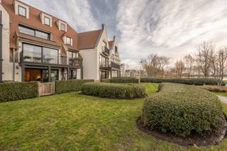 Zonnig en knap afgewerkt appartement met prachtig zicht op het meer van Duinenwater, genietend van een zuid-west georiënteerd terras en tuintje.<br />Indeling:<br />Inkom met gastentoilet en vestiaire.<br />Open luxueuze keuken voorzien van alle toestellen, eetplaats en lichtrijke salon uitgevend op het zonnig terras en de tuin.<br />2 volwaardige slaapkamers uitgevend op groen aan de achterzijde. Badkamer (bad/douche - dubbele lavabo en wc). Berging voor wasmachine en droogkast. <br />2 privatieve kelderbergingen inbegrepen in de aankoop.<br />Mogelijkheid tot het aankopen van een zeer goede en ruime garagebox in de residentie.<br />Gemeenschappelijke fietsenberging.<br />Bezoek aan dit mooie aanbod warm aanbevolen en steeds mogelijk op afspraak.