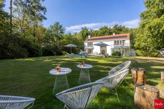 <p>Zoekt u het ultieme vakantiegevoel zonder uw huis te verlaten? Dan is deze villa de perfecte woning voor u. Deze luxe, moderne en zeer lichte villa bevindt zich in de groene, residentiële Bellemond wijk op een toplocatie te ’s Gravenwezel. Hier geniet u van volledige privacy in een prachtige zuidwest-georiënteerde tuin met een verwarmd zwembad. De villa is ideaal gelegen nabij scholen, openbaar vervoer en winkels, en ligt in een van de meest prestigieuze wijken van ’s Gravenwezel.</p>
<p>Deze architectenwoning, ontworpen door de gerenommeerde architect John Bontinck, is gebouwd met hoogwaardige materialen. De visie van de architect om de tuin sterk bij de woning te betrekken, is werkelijk verbluffend geslaagd. Bij binnenkomst wordt u meteen gecharmeerd door het vakantiegevoel dat de villa uitstraalt. Een prachtige doorkijk naar de tuin en het zwembad verwelkomt u direct.<br /><br />INDELING<br /><br /><strong>Gelijkvloers:<br /></strong>Bij binnenkomst wordt u meteen gecharmeerd door het vakantiegevoel dat de villa uitstraalt. Een prachtige doorkijk naar de tuin en het zwembad verwelkomt u direct. <br />U treedt de villa binnen via een inkomhal met een apart gastentoilet en een ruime vestiaire. Een dubbele glazen deur biedt toegang tot de riante en lichte woonkamer met een doorlopend raam tot de verdieping. De leefruimte, verdeeld in zithoek, salon en eetkamer, is voorzien van een eiken parketvloer en een prachtig open haard. De ruimtes vloeien mooi in elkaar over en zijn in direct contact via grote deurramen met het zuidwest-georiënteerde terras, de tuin en het zwembad.<br /><br />Aansluitend aan de leefruimte vindt u de volledig geïnstalleerde keuken met een kookeiland, ontbijthoek, tal van opbergkasten en moderne toestellen, waaronder een Amerikaanse koelkast. Door kamerhoge raampartijen rondom de keuken wordt deze ruimte overspoeld met natuurlijk licht en biedt het een prachtig uitzicht op de tuin en het zwembad.<br /><br />Een praktische douchekamer met toegang naar buiten is ideaal na een zwembeurt in het zwembad.<br /><br />Een mooie houten trap leidt naar de eerste verdieping, waar een impressionante vide extra licht en uitzicht biedt vanuit de verdieping op de prachtige tuin.<br /><br /><strong>1e Verdieping:<br /></strong>Op de 1e verdieping vindt u de mastersuite met dressing en badkamer – met ligbad, dubbele lavabo en toilet. De 2e slaapkamer (ca. 31m²) op parket met ingemaakte kasten geeft uit op een prachtig terras. De 2e (ca. 20m²) en 4e slaapkamers (ca. 18m²) delen de 2e badkamer met ligbad, lavabo en toilet. Verder is er nog een handige berging, ideaal voor een linnenkast of een extra douchekamer.<br /><br /><strong>Tuin en Zwembad<br /></strong>Geniet volop van de zonnige tuin in volledige privacy zonder enige inkijk. De tuin is aangelegd met verschillende terrassen, een verwarmd zwembad en een tuinhuis. Deze buitenruimte biedt de perfecte setting voor ontspanning, zomerse barbecues en gezellige avonden.<br /><br />Een inpandige garage biedt ruimte voor 2 wagens en heeft een automatische toegangspoort. Daarnaast is er een ruime oprit met plaats voor meerdere wagens, wat extra gemak en parkeerruimte biedt voor u en uw gasten.<br /><br />Kortom, deze villa is een waar paradijs voor wie houdt van een luxe levensstijl met een vleugje vakantie. De ruime indeling en grote ramen zorgen voor een lichte en luchtige sfeer. Mis deze unieke kans niet om in een van de meest gewilde wijken van ’s Gravenwezel te wonen.</p>
<p></p>
<p>BIJZONDERHEDEN:<br />+ Architect John Bontinck<br />+ Nieuw gietvloeren op verschillende ruimtes<br />+ Vloerverwarming <br />+ 15 zonnepanelen (2024)<br />+ Gunstig EPC: 164kWh/m²<br />+ Vloerverwarming op GLV<br />+ Asbestvrij.<br />+ Bose audio-installatie in alle ruimtes, voor optimale geluidservaring.<br /><br />Voor meer informatie of een bezoek aan deze gezellige woning, neem gerust contact op met Sigalit via Sigalit@reds.be of op 0475668474</p>