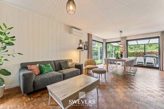 Voor meer info en foto’s, surf naar www.swevers.be –Deze instapklare open bebouwing aan de Wijerstraat 25 in Zonhoven combineert modern wooncomfort, energiezuinige voorzieningen en een ruim perceel van 8a 24ca met zuidwestelijke oriëntatie. De woning werd gebouwd in 2011, vernieuwd in 2023 en beschikt over een bewoonbare oppervlakte van 189 m². Op het gelijkvloers vindt u een inkomhal met gastentoilet en een lichtrijke leefruimte van 36 m². De open keuken van 18,4 m² met kookeiland sluit hier mooi op aan. Verder is er een bureau van 13,11 m² dat ook als derde slaapkamer kan dienen, evenals een praktische berging met wasvoorzieningen. De eerste verdieping telt twee volwaardige slaapkamers, waarvan één met dressing. De badkamer beschikt over een ligbad, dubbele wastafel en toilet. Ook op energetisch vlak scoort deze woning goed dankzij vloerverwarming op het gelijkvloers, gasradiatoren, twee airco-units, een warmtepompboiler uit 2023 en 16 zonnepanelen uit 2021 met een opgegeven jaaropbrengst van circa 6.000 kWh. Buiten geniet u van een ruime, zuidwestelijk gerichte tuin met terrasoverkapping en tuinhuis uit 2020. Ideaal om in alle rust van de namiddag- en avondzon te genieten. De ligging is eveneens gunstig, met openbaar vervoer op 280 meter, scholen op 2 km, winkels op 2,5 km en de snelweg op 3,8 km. Een comfortabele, energiezuinige gezinswoning met tal van mogelijkheden! Voor meer informatie, bel 011 255 155. Bron bewoonbare oppervlakte: EPC – verslag.
