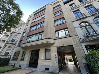 ONMIDDELLIJK BESCHIKBAAR - ZELDZAAM AANBOD.Gelegen in een karaktervol gebouw uit 1936 van de hand van architect Michel Polak (Villa Empain), werd dit doorzonappartement zorgvuldig gerenoveerd met behoud van authentieke charme en hedendaags comfort.HET APPARTEMENT: - Lichtrijke woonkamer met prachtige originele visgraatparket en decoratieve open haard. - Ingerichte keuken met toegang tot een aangenaam terras aan de achterzijde (binnenterrein). - Rustig gelegen hoofdslaapkamer. - Apart bureau (ideaal voor telewerk of als grote dressing). - Ruime, moderne badkamer met de luxe van een ligbad EN een inloopdouche. - Inkomhal met apart toilet en vestiaire. UNIEKE TROEVEN (INBEGREPEN): - GARAGE: Een afgesloten box op de beveiligde binnenplaats (een absolute luxe in de wijk).- PRIVÉ KELDER: Een exclusieve wasplaats, reeds uitgerust (wasmachine en droogkast) en ingericht met een wijnkelder.- HET GEBOUW: Een prestigieuze mede-eigendom met gevel in witte steen en baksteen. U wordt verwelkomd door een majestueuze marmeren inkomhal met spiegels en standbeelden, getuigen van de Brusselse modernistische elegantie.TECHNISCHE INFO: - Hoogwaardige dubbele beglazing. - Videofoon. - Gepantserde deur. Een niet te missen kans voor liefhebbers van architectuur die op zoek zijn naar totaalcomfort (parking en bergruimte). Bezoeken op afspraak.