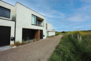 Bent u op zoek naar een energiezuinige woning op een toplocatie aan zee? Dan zal deze recente nieuwbouwwoning met <strong>energie-label A</strong> u ongetwijfeld weten te bekoren. Gelegen in een rustige en verzorgde nieuwe woonwijk in Mariakerke-Oostende, geniet u hier van een uitzonderlijke ligging op wandelafstand van de Zeedijk, het strand, de duinen, talrijke wandel- en fietsroutes, openbaar vervoer en diverse voorzieningen.<br />De woning werd afgewerkt met oog voor comfort en functionaliteit en biedt een aangename woonbeleving dankzij haar doordachte indeling en kwalitatieve afwerking.<br /><strong>Indeling gelijkvloers:</strong>
<ul>
<li><span>Ruime inkomhal voorzien van een alarmsysteem en praktische ingemaakte kasten.</span></li>
<li><span>Apart gastentoilet.</span></li>
<li><span>Lichtrijke leefruimte met gezellige eetplaats, voorzien van vloerverwarming en een stijlvolle ingebouwde gashaard die onmiddellijk zorgt voor een warme en sfeervolle uitstraling.</span></li>
<li><span>Praktische bureauruimte geïntegreerd in de woonkamer, ideaal voor thuiswerk.</span></li>
<li><span>Volledig uitgeruste keuken volledig uitgerust met ingebouwde toestellen: koelkast, diepvries, combi-oven, stoomoven, vaatwasser, … noem maar op.</span></li>
<li><span>Ruime berging/wasplaats.</span></li>
<li><span>Aan de voorzijde van de woning bevindt zich een aangenaam terras waar u in alle rust van de ochtendzon kunt genieten.</span></li>
<li><span>Via het schuifraam bereikt u de zuidgerichte tuin met aangelegde grasmatten en ruim terras.</span></li>
<li><span>Praktisch tuinhuis met extra opbergmogelijkheden.</span></li>
<li><span>In het verlengde van de tuin bevindt zich een poort die toegang geeft tot de achterzijde van het perceel, waar twee private staanplaatsen voorzien zijn.</span></li>
</ul>
<strong>Eerste verdieping:</strong>
<ul>
<li><span>Ruime master bedroom met toegang tot een zonnig terras en een prachtig uitzicht op de duinen.</span></li>
<li><span>Tweede volwaardige slaapkamer voorzien van een eigen douche en lavabo.</span></li>
<li><span>Derde slaapkamer, momenteel ingericht als bureauruimte, maar perfect bruikbaar als slaapkamer of hobbykamer.</span></li>
<li><span>Badkamer voorzien van zowel ligbad als douche en een dubbele wastafel.</span></li>
</ul>
<strong>Extra troeven:</strong>
<ul>
<li><span>Energiezuinige woning met <strong>EPC-label A</strong></span></li>
<li><span>Zonnepanelen aanwezig</span></li>
<li><span>Vloerverwarming</span></li>
<li><span>Zonnewering voorzien</span></li>
<li><span>Alarmsysteem</span></li>
<li><span>Twee private staanplaatsen</span></li>
<li><span>Elektrische installatie conform het AREI</span></li>
<li><span>Zuidgerichte tuin</span></li>
<li><span>Unieke ligging nabij zee, strand en duinen</span></li>
</ul>
Deze woning combineert een uitstekende ligging met hedendaags wooncomfort en energiezuinigheid. Een unieke kans voor wie op zoek is naar een vaste woonplaats, tweede verblijf of investering aan de Belgische kust.<br /><strong>Wenst u deze parel te bezichtigen?</strong><br />Neem dan vrijblijvend contact op via <strong>0495/50.69.20</strong> of stuur een e-mail naar <strong>nicolas@jolieinvest.be</strong><br />