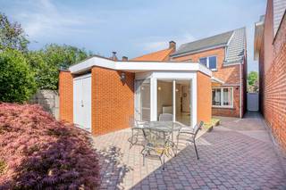 <p><span><strong>Ruime gezinswoning met tuin nabij het centrum van Retie.</strong></span><br /><br />We betreden de woning via de inkomhal, die meteen toegang biedt tot de leefruimte en de trap naar de eerste verdieping. De leefruimte voelt aangenaam en huiselijk aan, met een vaste kastenwand die perfect dienstdoet als tv-meubel en een charmante sierhaard die karakter toevoegt aan het geheel.</p>
<p>Aansluitend bevindt zich de eetkamer in open verbinding met de leefruimte. Deze ruimte leent zich uitstekend voor gezellige diners of het ontvangen van gasten. Vanuit de eetkamer is er een vlotte doorgang naar de keuken, die voorzien is van het nodige comfort en voldoende opbergruimte.</p>
<p>De keuken staat in open contact met een lichtrijke veranda die ideaal is als ontbijthoek. Hier geniet je van een mooi uitzicht op de westgerichte tuin, compleet met een verzorgd terras en een praktisch tuinhuis. Daarnaast is er een aparte buitenberging voorzien, perfect voor het opbergen van vuilnisbakken of tuingereedschap.</p>
<p>Via de achteringang bereiken we een apart gastentoilet en de eerste badkamer. Deze is uitgerust met een douchecabine, een badkamermeubel met enkele wastafel en aansluitingen voor de wasmachine.</p>
<p>Op de eerste verdieping leidt de nachthal naar twee volwaardige slaapkamers. Verder is er nog een extra ruimte die perfect kan dienen als berging. De tweede badkamer beschikt over een ligbad, een toilet en een badkamermeubel met enkele wastafel.</p>
<p>Tot slot is er voor de woning voldoende ruimte om twee wagens te parkeren, wat het comfort van deze charmante woning nabij het centrum van Retie compleet maakt.</p>