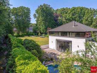 <strong>TE KOOP MET PRE-VIEW: enkel op afspraak.</strong><br /><br />Uniek gelegen moderne villa met zwembad, pal aan het park van Halle-Zoersel.<br /><br />Op een uitzonderlijke, groene toplocatie in Halle-Zoersel, direct grenzend aan het Hallehof, vindt u deze moderne, royale villa. Hier woont u in alle rust en privacy, met een prachtig, blijvend groen uitzicht en tegelijk een woning met enorm veel ruimte en mogelijkheden.<br /><br /><strong>Ligging</strong><br />+ Onmiddellijke aansluiting op het park van Halle-Zoersel<br />+ Volledige privacy, geen inkijk<br />+ Rustige, residentiële omgeving<br />+ Ideaal voor wie houdt van natuur, wandelen en fietsen<br /><br /><strong>INDELING</strong><br /><br /><span>Gelijkvloers:</span><br />Via de inkomhal met gastentoilet betreedt u de lichtrijke leefruimte, waar zithoek en eetkamer subtiel van elkaar gescheiden worden door een sfeervolle houthaard. De grote raampartijen zorgen voor een overvloed aan natuurlijk licht en een prachtig zicht op de tuin en het groen.<br />Aansluitend bevindt zich de functionele keuken, die verbonden is met een praktische berging en wasplaats met rechtstreekse zij-ingang. Vanuit deze berging bereikt u een polyvalente kamer, eveneens toegankelijk vanuit de inkomhal. Deze ruimte kan perfect dienen als bureau, praktijkruimte aan huis, fitness- of hobbyruimte, speelkamer of ontspanningsruimte.<br /><br /><span>Verdieping:</span><br />De centraal geplaatste trap in de leefruimte, als echte blikvanger voor het grote tuinraam, leidt naar de nachthal met apart toilet. Op deze verdieping bevinden zich:<br />+ 5 ruime kamers<br />+ 2 badkamers:<br />badkamer 1 met ligbad, douche en dubbele lavabo<br />badkamer 2 met douche en dubbele lavabo<br /><br /><span>Buitenruimte:</span><br />De west-georiënteerde tuin is een ware oase van rust, volledig omkaderd door groen en met directe aansluiting op het park.<br />+ Volledige privacy<br />+ Verwarmd zwembad, ideaal voor zalige zomerdagen<br />+ Genieten van de namiddag- en avondzon<br />+ Praktische bergingen<br /><br /><strong>BIJZONDERHEDEN<br /></strong><br />+ Zeer praktische, dubbele inpandige garage<br />+ Ruime oprit + extra carport<br />+ Zolder, toegankelijk via vouwtrap<br />+ Woning voorzien van kruipruimte<br />+ Vloerverwarming op het gelijkvloers<br />+ Airco/warmtepomp in de slaapkamer, leefruimte, keuken, bureau<br />+ Sfeervolle houthaard in de living<br />+ Ingemaakte kasten voor extra bergruimte<br />+ Buitenscreen aan het grote tuinraam<br />+ Elektricteit is conform<br />+ Alarm <br /><br />Deze villa combineert een unieke bosrandligging met een zee aan ruimte, optimaal comfort en tal van indelingsmogelijkheden.<br /><br />Contacteer ons voor meer informatie of om uw bezoek in te plannen en laat u ter plaatse overtuigen door de unieke sfeer en ligging van deze uitzonderlijke eigendom.