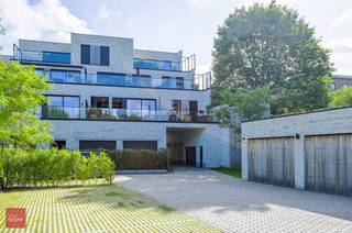 Inkomhal met vestiaire en toilet, lichtrijke living in parket en grote schuiframen met automatisch bedienbare zonnewering, open ingerichte...