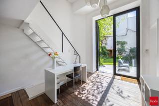 <p>Uniek herenhuis met zuidtuin, zwemvijver en veelzijdig karakter op absolute toplocatie.</p>
<p>Met veel enthousiasme presenteren wij dit uitzonderlijke herenhuis aan de Vlaamsekaai, ongetwijfeld één van de meest gegeerde locaties van Antwerpen-Zuid. Deze riante woning in rijke, pittoreske neo-Vlaamse-renaissance stijl werd in 1879 ontworpen door de vermaarde architect J.V. Delpierre in opdracht van de Waalse baron de Senzeille. Een heus stukje Antwerpse geschiedenis dus, aan de mooiste hoek van het populaire Zuidpark én pal in het hart van de meest bruisende buurt. Toch schuilt er achter de statige gevel een oase van stilte en achter de elektrische poort een prachtige, heerlijk rustgevende tuin waar u onmiddellijk de drukte van de stad afschudt en zich meteen in de Provence waant.</p>
<p>Het ruime gelijkvloers met enkele originele elementen én hoge plafonds is vergund als commerciële ruimte en momenteel ingericht als galerij met mezzanine. Achterin is er een recent vernieuwd badkamertje met douche, toilet en lavabo. Deze etage is dus ideaal als praktijkruimte, showroom en atelier, of voor specialisten of vrije beroepen die wonen en werken willen combineren op een zeer commerciële locatie.</p>
<p>Een plafondhoge glazen deur geeft uit op de onvolprezen blikvanger: de fraaie tuin met zwemvijver van net geen tien meter lengte. Het is een biologische zwemvijver: dus géén chloor of chemicaliën, wel zuiver, heerlijk verfrissend water. Een zeldzame troef op deze locatie. Onmogelijk om tegelijk in de stad én op de buiten te wonen? Wellicht wel, al komt dit wel zeer dichtbij dat unieke gevoel.</p>
<p>De indrukwekkend ruime én hoge kelder kan fungeren als opslag, wijnkelder, hobbyruimte of praktische stockage. Hij doet momenteel dienst als magazijn voor boeken. Achterin is er tevens een kleine keuken met daglicht, gas en water.</p>
<p>De authentieke traphal ademt grandeur en elegantie, terwijl een tweede binnentrap de verschillende leefruimtes en tussenverdiepingen met elkaar verbindt. De eerste etage bestaat uit twee royale bureaus met originele eiken vloeren, houten deuren en zicht op de tuin of het park. Er is eveneens een praktische bijkeuken en wasruimte.</p>
<p>Beide slaapkamers op de tweede verdieping ademen elk een eigen sfeer. De master bedroom aan de achterzijde is zeer stil, kijkt uit op de tuin, beschikt over airconditioning en een recent vernieuwde ensuite badkamer met lavabo, toilet en een goed toegankelijke inloopdouche. De zeer ruime slaapkamer vooraan heeft opnieuw een authentieke eiken vloer én zicht op het Zuidpark. De aansluitende dressing baadt dankzij de mooie raampartij ’s avonds in prachtig zonlicht. Een huis waar je zowel voor als achteraan van bomen, natuur en vrolijk zingende vogeltjes kan genieten: ook dit blijft uiterst zeldzaam in de stad.</p>
<p>Het pas gerenoveerde, lichtrijke en volledig geïsoleerde leefgedeelte op de bovenste verdieping heeft airconditioning en sluit aan op de onlangs gerenoveerde keuken. Dankzij een kamerbrede schuifdeur lijken woonkamer en het aangename, zuidgerichte terras wel één geheel. Het terras baadt in rust en kijkt uit op de paarden bovenop het KMSKA.</p>
<p>De woning beschikt over dubbele beglazing in hardhouten raamprofielen en combineert authentieke charme met hedendaags wooncomfort. Dit uitzonderlijke, zeer ruime pand op een absolute toplocatie in Antwerpen-Zuid is vooral erg flexibel en daarom zowel interessant als investering of als woning. Met zijn drie boilers en drie digitale meters en vele nutsvoorzieningen kan het relatief eenvoudig worden opgedeeld in appartementen. Het kan eveneens dienen als gastenkamers, wellness of voor mensen met een vrij beroep die wonen en werken willen combineren. Parkeren is géén probleem. Recht over de deur ligt onder het park een giga parkeergarage met zeer voordelige voorwaarden voor bewoners.</p>
<p>Voor meer informatie of een persoonlijke rondleiding kan u contact opnemen met Amparo op +32 478 68 29 86 of via amparo@reds.be.</p>