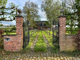 Unieke landelijke eigendom met 52,55 are grond en uitgebreide bijgebouwen – ideaal voor paardenliefhebbers<br /><br />Op een uitzonderlijk rustige en volledig afgelegen locatie in het groene Schoonaarde bevindt zich deze charmante eigendom op een perceel van maar liefst 52,55 are (5255m²). Hier geniet u elke dag van een prachtig open zicht over de omliggende velden en wordt u wakker in alle rust.<br /><br />De woning beschikt op het lichtrijke gelijkvloers over een keuken, een berging, een leefruimte, een veranda met zicht op de achtertuin en omliggende velden, een droge kelder en een slaapkamer. Op de eerste verdieping vindt u een ruime nachthal met open bureaugedeelte, een grote slaapkamer, een bijkomende kamer, evenals een badkamer en toilet.<br /><br />Buiten is deze eigendom een absolute troef voor wie ruimte en mogelijkheden zoekt. Met maar liefst 600 m² aan bijgebouwen biedt dit domein tal van functies: een stal, een garage met twee automatische poorten, een werkatelier, een ingerichte studio en een ruime overdekte carport geschikt voor vijf wagens.<br /><br />Het perceel is volledig ingericht voor paardenliefhebbers, met drie omheinde weides voorzien van schrikdraad, automatische drinkbakken en beregening, alles beheerd vanuit het bijgebouw.<br /><br />Daarnaast is het terrein mooi beplant met onder andere diverse leibomen, sierlijke wilgen en twee notelaars wat bijdraagt aan het unieke, landelijke karakter van deze eigendom.<br /><br />Ondanks de uiterst rustige en groene ligging geniet u hier van een uitstekende bereikbaarheid. De woning bevindt zich op tien minuten van het centrum van Dendermonde. Openbaar vervoer is vlot toegankelijk met een bushalte op slechts 300 meter en het station van Schoonaarde op ongeveer 1 kilometer. Bovendien bevinden zich meerdere grootwarenhuizen op slechts 2 kilometer afstand.<br /><br />Bent u op zoek naar rust, ruimte en een multifunctioneel domein in een groene omgeving, zonder in te boeten aan bereikbaarheid? Dan is dit een zeldzame kans!