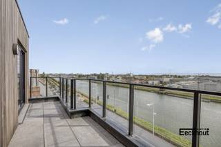 Deze lichtrijke penthouse met hoogwaardige afwerking bevindt zich in de recente nieuwbouwresidentie 'Hypoliet' te Bredene, op een unieke ligging met adembenemende verzichten over het kanaal. De residentie is vlot bereikbaar en bevindt zich vlakbij winkels, het Shoppingcentrum van Bredene, openbaar vervoer en de kust.<br />Indeling: grote inkomhal voorzien van ingemaakte kasten en aansluiting voor wasmachine, woonkamer met open, ingerichte keuken en veel kastruimte, aansluitend zonneterras, slaapkamer met ruimte voor het maken van een dressing en badkamer met douche en lavabomeubel, apart toilet en tweede zonneterras.<br />Vanuit de leefruimte geniet men van een onvergetelijk uitzicht over het kanaal en dankzij de grote raampartijen baadt het appartement in natuurlijk licht. <br />Bovendien voldoet dit appartement aan alle hedendaagse normen: elektriciteit is comform, het appartement is asbestvrij en is zeer energiezuinig (EPC A)! Er zijn zelfs zonnepanelen aanwezig ten voordele van dit appartement.<br />Mogelijkheid tot aankoop van een garagebox met automatische sectionale poort in het gebouw!<br />Een zeldzame kans die u niet mag missen – contacteer ons vandaag nog voor een bezoek!<br />Verkoop onder BTW.