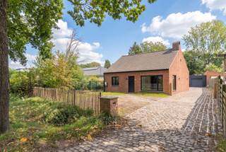 <strong>Gerenoveerde woning met 3 slpk en grote vergunde garage/werkplaats op 1.705 m²<br /></strong>EPC B I Goedgekeurde elektriciteit I vergunde garage van 80 m²<strong><br /><br />Gunstig gelegen</strong>,<strong> </strong>nabij de Klein Engelandhoeve met heel wat natuur- en wandelgebieden in de onmiddellijke omgeving doch met een vlotte bereikbaarheid naar het centrum en de Ring, alsook naar de grens met Nederland.<br /><br />Deze woning <strong>werd recent (2025) volledig vernieuwd </strong>en voorzien van nieuwe ramen met driedubbele beglazing, elektriciteit, airco's, warmtepomp, nieuwe keuken en badkamer, zonnepanelen enz.<br />Zij bestaat uit een inkomhal, een gezellige woonkamer met open volledig vernieuwde keuken. Deze keuken werd knap ingericht met een prominent SMEG fornuis met inductiekookplaat, 2 ovens en een grill, een vaatwasser en SMEG microgolfoven. Van hieruit ook een zij-ingang naar buiten. Vanuit de nachthal bereiken we 3 ruime slaapkamers waarvan 2 met airco en de volledig vernieuwde badkamer<strong> </strong>die werd ingericht met een vrijstaand bad, een inloopdouche, wastafel en toilet en een echt pareltje is. Achteraan nog een berging/wasplaats die rechtstreeks toegang geeft naar buiten. Achter de woning staat een grote garage/werkplaats met automatische poort van 80 m² die werd ingericht met een kleinere bureau of werkruimte en aparte toilet en zij-toegang. Het perceel grenst achteraan aan agrarisch gebied en het Bels lijntje en biedt zo zekerheid tot een mooi en blijvend groen zicht. In de tuin mag men tevens een zwembad en kleinere stal voorzien. Ideaal voor het houden van dieren aan huis. Ook ideaal voor een zelfstandige op zoek naar een werkplaats aan huis of hobby-ist<br /><br /><strong>Bijzonderheden:</strong><br />-Goedgekeurde elektriciteit <strong>tem 2050</strong><br />-Energiezuinig B label (<strong>115 Kwh/m²)</strong><br />-<strong>20 Zonnepanelen (2021)</strong><br />-<strong>Vergunde garage/werkplaats van 80 m²</strong><br />-Perceel geschikt voor het houden van dieren aan huis <br />-Stal en zwembad ook mogelijk<br />-de woning werd ondertussen ook asbestvrij gemaakt
