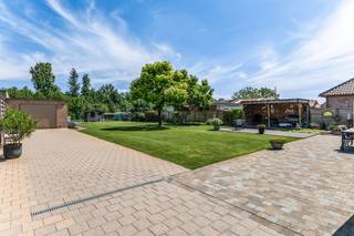 Instapklare en energiezuinige open bebouwing met 4 slaapkamers, 2 garages en prachtige tuin op een perceel van 1.383 m² op een centrale locatie te Ranst, bestaande uit: inkomhal met ruimte voor vestiaire en apart toilet met handenwasser; woonkamer met houtkachel en directe toegang tot een fantastische tuin met ruim terras; recente keuken (dd. 2022) voorzien van inductie kookplaat, dampkap, oven, combi-oven, vaatwasser en koelkast; handige bijkeuken met aansluiting voor was- en droogautomaat en inpandige garage met automatische poort. Op de verdieping: nachthal met apart toilet, 4 slaapkamers, recente badkamer (dd. 2022) voorzien van inloopdouche en lavabomeubel. Voorts beschikt de woning nog over een extra garage in de tuin, ruime oprit, mooie aangelegde tuin met ingebouwd verwarmd zwembad (diameter 5 meter met warmtepomp), tuinberging en ideale zuid-oost oriëntatie. Centrale verwarming op aardgas d.m.v. condensatieketel, PVC schrijnwerk met dubbele beglazing en automatische rolluiken, airco, alarm, regenwaterrecuperatie, 21 zonnepanelen met nog lopende groenestroomcertificaten, ... Beschikbaar bij akte. EPC: 164 kWh/m².