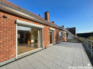 <strong>Royaal appartement (117 m²) met tuin, zuidwest-terras en parkings</strong><br />
<p>Bent u op zoek naar een ruim appartement met de vrijheid van een huis? Dit appartement van 117 m² op de eerste verdieping biedt u veel privacy, een prachtige buitenruimte.</p>
<p><strong>Toegang en binnenkomen,</strong> U bereikt het appartement via een <strong>eigen buitentrap</strong>. Omdat er geen lift en geen gemeenschappelijke hal is, heeft u hier <strong>geen gemeenschappelijke kosten</strong> (geen syndicus). U geniet van volledige onafhankelijkheid. U komt binnen in de inkomhal, die dankzij de praktische ingebouwde kasten direct zorgt voor voldoende opbergruimte.</p>
<p><strong>Leven en koken,</strong> De living is bijzonder ruim en lichtrijk, wat tal van inrichtingsmogelijkheden biedt. Aansluitend vindt u de keuken. Deze is netjes uitgerust, maar wordt aangeboden <em>zonder</em> koelkast, zodat u de vrijheid heeft om uw eigen vrijstaand toestel te plaatsen.</p>
<p><strong>Slapen en baden,</strong> Het appartement beschikt over twee volwaardige slaapkamers. De badkamer is voorzien van een dubbele lavabo en bad met douchescherm, en er is een apart toilet in de hal.</p>
<p><strong>Buitenleven &amp; Tuin,</strong> Aan buitenruimte geen gebrek! U geniet van een ruim terras dat <strong>zuidwest gericht</strong> is – ideaal voor de middag- en avondzon. Daarnaast hoort er ook een tuin bij het appartement.</p>
<p><strong>Parkeren en onderhoud,</strong> Er zijn parkeerplaatsen inbegrepen. <strong>Omdat er geen maandelijkse lasten zijn, staat u zelf in voor het onderhoud van uw 'eigen stukje'</strong>: dit omvat het proper houden van de buitentrap, de directe omgeving ervan en de parkings met bijbehorende groenzone.</p>
<p><strong>Kortom:</strong> Een ideaal appartement voor wie zoekt naar ruimte, geen vaste kosten en graag de handen uit de mouwen steekt om de eigen omgeving groen en netjes te houden.</p>