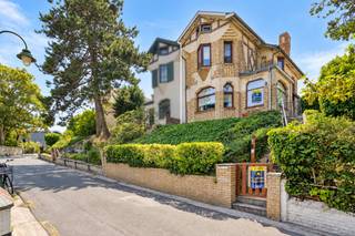 Maison mitoyenne idéalement située dans le quartier Dumont de De Panne, à distance de marche de la plage et du marché.<br /><br /><strong>Disposition de la maison :</strong>
<ul>
	<li><strong>Rez-de-chaussée</strong> : Vous entrez dans un hall d'entrée spacieux qui donne accès à un salon lumineux. La cuisine fonctionnelle s'intègre parfaitement à l'espace repas. De plus, au rez-de-chaussée, il y a un WC séparé pour les invités.</li>
	<li><strong>Premier étage :</strong> À cet étage se trouvent deux chambres spacieuses et lumineuses. La salle de bains est équipée d'une douche à l'italienne confortable, d'un toilette et d'un meuble lavabo.</li>
	<li><strong>Combles</strong> : Les combles offrent de nombreuses possibilités et peuvent parfaitement être aménagés en troisième chambre, atelier, bureau ou salle de jeux.</li>
	<li><strong>Espace extérieur</strong> : Le jardin ensoleillé avec agréable terrasse constitue l'endroit idéal pour profiter de moments de calme.</li>
</ul>
<br /><strong>ATOUTS :</strong>

<ul>
	<li>Emplacement calme et proche de tout</li>
	<li>Au cœur du quartier Dumont</li>
	<li>Idéal pour la location de vacances</li>
</ul>
ATTENTION : Ce bien nécessite une rénovation complète. Certaines photos de l’annonce ont été générées à l’aide de l’intelligence artificielle et sont uniquement destinées à illustrer une possibilité d’aménagement et de rénovation future.<br />L’installation électrique n’est pas conforme.