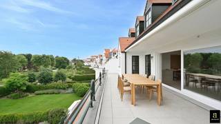 <span>Dit exceptionele appartement met zuidgericht terras is gelegen in het uiterst prestigieuze en groene domein Tennis Gardens, nabij de Royal Zoute Tennis Club en op wandelafstand van zowel het strand als het natuurgebied Het Zwin. Via de inkomhal met gastentoilet en vestiaire betreedt men de royale leefruimte, waar licht, ruimte en rust centraal staan. Grote raampartijen geven uit op een breed, zonnig terras met een prachtig, open zicht op de tuinen van dit exclusieve privé domein – een oase van groen en privacy. Prachtige open keuken met ontbijthoek. Wasruimte/berging, discreet geïntegreerd voor optimaal comfort. Het nachtgedeelte omvat drie volwaardige tweepersoonsslaapkamers, elk voorzien van een privatieve douchekamer. Twee slaapkamers genieten van directe toegang tot een achterliggend terras. Mogelijkheid tot aankoop van een ruime garagebox binnen de residentie, geschikt voor twee wagens achter elkaar. Privatieve kelder. Fietsenberging. Een zeldzaam aanbod voor wie op zoek is naar een hoogwaardig appartement op een uitzonderlijke locatie, waar rust, groen en exclusiviteit harmonieus samenkomen.</span>