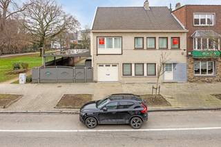 Aan de Naamsevest 51, vlak bij het cultureel centrum, bevindt zich deze uitzonderlijke villa die ruimte, luxe en een absolute toplocatie combineert. Dankzij haar unieke positie, grenzend aan het groene Pater Damiaanhof en zonder directe buren, geniet u hier van volledige rust en privacy, midden in het bruisende centrum van Sint-Truiden.<br /><br />Bij het binnenkomen verwelkomt een stijlvolle inkomhal met gastentoilet u in deze elegante woning. De ruime living met eetkamer (40 m²) vormt samen met de aangrenzende leefruimte een harmonieus geheel. Een volledige wand met maatwerk inbouwkasten in hoogwaardig hout biedt zowel esthetisch als praktisch comfort. De overvloedige lichtinval en verfijnde afwerking creëren een warme, uitnodigende sfeer.<br /><br />De keuken is een droom voor elke kookliefhebber: uitgerust met topapparatuur van Miele, waaronder een extra groot inductievuur, stoomoven, microgolfoven, warmtelade en Amerikaanse koelkast. Het natuurstenen werkblad en de talrijke ingebouwde kasten combineren elegantie met gebruiksgemak. De leefruimte sluit aan op de luxueuze veranda van 55 m², uitgevoerd met aluminium raamprofielen. Dit is de ideale plek om het hele jaar door te genieten van het uitzicht op de groene, perfect georiënteerde tuin.<br /><br />Unieke meerwaarde: naast de ruime oprit beschikt u over een inpandige garage met elektrische sectionaalpoort en een carport met elektrische toegangspoort, goed voor meerdere wagens. Een echte zeldzaamheid in het centrum. De carport bevindt zich bovendien op een extra perceel bouwgrond, een volledig ommuurde ‘clos’ die extra privacy en exclusiviteit biedt.<br />Op de bovenverdieping bevinden zich vier royale slaapkamers (elk minstens 16 m²), allemaal voorzien van praktische inbouwkasten. De master bedroom beschikt over een elegante walk-in dressing (8 m²). De badkamer is luxueus afgewerkt en uitgerust met een ruime douche, ligbad, dubbele lavabo en toilet. De volledige verdieping is bekleed met hoogwaardig parket, wat zorgt voor een warme en klassevolle uitstraling.<br /><br />De zolder van ca. 60 m² biedt nog tal van mogelijkheden. Dankzij de aanwezige isolatie en dakbedekking kan deze ruimte eenvoudig worden ingericht als extra slaapkamer(s), bureau, hobbyruimte of polyvalente ruimte.<br /><br />Technisch is het pand grotendeels up-to-date: vernieuwde elektriciteit, ramen met dubbel glas en hoewel de centrale verwarming nog op stookolie is met een Viessmann-ketel, is er wel reeds gas ingeleid aan de voordeur.  Verder zorgt de waterverzachter nog voor bijkomend comfort.<br /><br />Kortom: deze villa biedt een unieke combinatie van ruimte, rust, luxe en bereikbaarheid, met parameters die in het stadscentrum zelden voorkomen: een tuin, meerdere autostaanplaatsen, garage, carport én geen directe buren dankzij de ligging naast het park.<br /><br />Of u nu droomt van een exclusieve gezinswoning, een representatief kantoor of een combinatie van beide, dit is een zeldzame kans in het hart van Sint-Truiden. Of u nu droomt van een private woning, een top-end kantoor/praktijk of een mix van beide? Aarzel dan niet om ons te contacteren voor meer informatie of een bezoek ter plaatse!