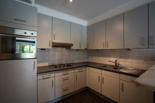 Rustig gelegen gelijkvloers appartement.Inkomhal met apart toilet.Lichtrijke woonkamer met open keuken (voorzien van alle toestellen) en toegang tot...