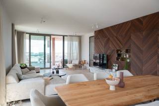 <br />Op de 13de verdieping van het prestigieuze gebouw Pergola, in de vernieuwde wijk de Nieuwe Dokken in Gent, bevindt zich deze exclusieve penthouse. Dankzij de terrassen rondom geniet u van een spectaculair uitzicht over het water en de Gentse skyline, inclusief de drie torens.<br /><br />De penthouse telt drie volwaardige slaapkamers en drie uitgeruste badkamers. De master bedroom beschikt over een elegante dressing. De ruime leefruimte sluit naadloos aan op het hoofdterras en baadt in natuurlijk licht. Grote glaspartijen versterken het open karakter en brengen buiten naar binnen. Een aparte, praktische berging biedt extra comfort.<br /><br />De keuken is open en strak vormgegeven met hoogwaardige toestellen, vakkundig weggewerkt achter schuifpanelen. Duurzame materialen en oog voor detail zorgen voor een tijdloze en stijlvolle afwerking.<br /><br />Deze penthouse beschikt over privétoegang via de lift, is volledig omringd door terrassen en ligt in een autoluwe, duurzame woonwijk aan het water.<br /><br />Een unieke combinatie van rust, ruimte, uitzicht en kwaliteit.<br />Ideaal voor wie op zoek is naar een exclusieve woonervaring in Gent.<br /><br />📞 Contacteer ons voor meer info of een bezoek.