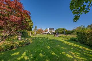<p>Deze uitzonderlijke villa in landelijk moderne stijl van +/- 330m² met landgebouw van +/- 200m2 combineert tijdloze architectuur met hedendaags wooncomfort en een bijzonder hoogwaardige afwerking. Het domein van ca. 8800m2 geniet van een open en uitgestrekt zicht op de royale tuin met exclusieve tuinarchitectuur grenzend aan agrarisch gebied, wat zorgt voor rust, privacy en een unieke woonbeleving. Bovendien is de villa gelegen in een doodlopende straat, wat garant staat voor een uiterst rustige en veilige omgeving. De woning kent met zijn centrale locatie in Humbeek een uitstekende verbinding naar Brussel en Antwerpen met de A12 en E19 in de nabijheid, wat deze locatie bijzonder interessant maakt voor wie rustig, maar centraal wil wonen.</p><p>U wordt verwelkomd in een stijlvolle inkomhal met ruimte voor vestiaire en gastentoilet met handenwasser. Via de karaktervolle deur bereikt u de lichtrijke leefruimte waar de eethoek naadloos overgaat in de keuken. De open keuken is het kloppend hart van de woning en werd volledig op maat ontworpen. De keuken is uitgerust met kwalitatieve toestellen en beschikt over een praktisch kookeiland met zicht op de tuin, ideaal voor wie graag kookt en tegelijk in contact wil blijven met familie of gasten. De uitnodigende zithoek heeft verbinding met zowel de eetkamer als de keuken met als eyecatcher de elegante doorkijkhaard. Via de bibliotheekruimte betreden we de riante en lichtrijke bureauruimte met uitgestrekt zicht op de tuin. Ideaal om werk en privé te combineren!</p><p>Vanuit de masterbedroom of het aangrenzend dakterras geniet u tevens van de verfijnde tuinarchitectuur en het adembenemend uitzicht over de akkers. Verder biedt de woning een vernieuwde badkamer, royale dressing, 2 grote slaapkamers en een extra badkamer. De kamer op de 2de verdieping kan gemakkelijk worden opgesplitst indien u meer kamers wenst.</p><p>Ook buiten is het heerlijk vertoeven. Je wordt betoverd door de exclusieve tuinarchitectuur waar u geniet van het rustgevend zicht of geniet van de zon aan het zwembad. Er is een buitendouche voorzien, alsook een poolhouse / studio in het landgebouw. Het landgebouw geeft tal van mogelijkheden voor het uitoefenen van een zelfstandige activiteit of als extra opslagplaats. Tevens is er in dit gebouw een studio voorzien (slaapkamer, woonkamer, badkamer en keuken). Er is voldoende parkeergelegenheid, alsook een dubbele carport en fietsenberging (voorzien van elektriciteit).</p><p>Bovendien is de woning voorzien van 40 zonnepanelen, dubbele laadpaal voor elektrische wagens, airco’s, een alarmsysteem, camerabewaking, tuinverlichting en een bewateringsysteem voor de tuin. </p><p>De combinatie van parketvloeren, natuursteen en hoogwaardige materialen zorgt voor een warme, luxueuze uitstraling die perfect aansluit bij de landelijke moderne architectuur. Kortom, een instapklare en bijzonder kwalitatieve villa met diverse mogelijkheden waar ruimte, licht, comfort en luxe harmonieus samenkomen in een rustige maar uiterst centrale ligging.</p><p>Deze woning is uiterlijk 1 juli 2027 beschikbaar.<br />Sted. inl. perceel 23036C0387/00W000: Vg - WgLK & Ag - Gmo - Gvkr - Gvv<br />Sted. inl. perceel 23036C0387/00A002: Vg - WgLK & Ag - Gmo - Gvkr - Gvv<br />Sted. inl. perceel 23036C0387/00Y00: Vg - WgLK & Ag - Gmo - Gvkr - Gvv<br />Sted. inl. perceel 23036C087/00V000: Vg - Ag - Gmo - Gvkr - Gvv </p>