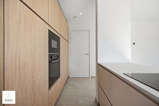 <strong>Exclusief gelijkvloers nieuwbouwappartement met uitzonderlijk ruim zonneterras</strong><br /><br />Bent u op zoek naar een stijlvolle woonst waar ruimte, comfort en energiezuinigheid centraal staan? Dan zal dit prachtige gelijkvloerse appartement in een kleinschalige residentie met slechts zes appartementen u ongetwijfeld bekoren.<br /><br />Dit hoogwaardig afgewerkte appartement onderscheidt zich door zijn hedendaagse architectuur, doordachte indeling en uitzonderlijk ruim terras, dat een naadloze overgang vormt tussen binnen en buiten. De royale leefruimte met grote raampartijen baadt in natuurlijk licht en sluit perfect aan op de moderne open keuken. Het ruime terras biedt alle mogelijkheden om in alle privacy te genieten van gezellige momenten met familie en vrienden.<br /><br />De woning beschikt over twee volwaardige slaapkamers, een stijlvolle badkamer en een apart gastentoilet. Dankzij de vloerverwarming in alle ruimtes, de energiezuinige warmtepomp en zes individuele zonepanelen geniet u van een optimaal wooncomfort en een bijzonder laag energieverbruik.<br /><br />De residentie is voorzien van een lift en combineert een rustige ligging met een uitstekende bereikbaarheid. Op wandelafstand vindt u het centrum met winkels, horeca en alle dagelijkse voorzieningen.<br /><br />Bij dit appartement is de aankoop van één ondergrondse autostaanplaats én één bovengrondse parkeerplaats verplicht, deze zijn inbegrepen in de prijs.<br /><br /><strong>Troeven van dit appartement:</strong>
<ul>
<li>Gelijkvloers appartement in een kleinschalige residentie met slechts 6 appartementen</li>
<li>Eigentijdse en kwalitatieve architectuur</li>
<li>Zeer ruim terras met optimale privacy</li>
<li>Lichtrijke leefruimte met grote raampartijen</li>
<li>Moderne open keuken</li>
<li>2 volwaardige slaapkamers</li>
<li>Stijlvolle badkamer en apart gastentoilet</li>
<li>Vloerverwarming in het volledige appartement</li>
<li>Energiezuinige warmtepomp en 6 individuele zonepanelen</li>
<li>Lift aanwezig</li>
<li>Rustige ligging op wandelafstand van het centrum</li>
<li>Onmiddellijk beschikbaar</li>
</ul>
Een ideale woongelegenheid voor wie op zoek is naar hedendaags wooncomfort, een energiezuinige woning en een uitzonderlijke buitenruimte op een rustige, maar centrale locatie.<br />