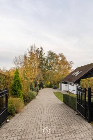 In het afgesloten en residentiële domein “Vlieringenpark” bevindt zich deze unieke villa, ontworpen in een verfijnde Scandinavische architectuurstijl en genietend van een prachtig, open vergezicht.<br /><br />De woning combineert een Scandinavisch design, natuurlijke materialen en functionaliteit en biedt bovendien tal van mogelijkheden, zoals het inrichten van een aparte studio voor een au pair of een bureau voor een vrij beroep.<br /><br />Indeling:<br />Gelijkvloers (0): Inkomhal met vestiaire en gastentoilet, ruime leefruimte met zithoek en eetplaats, volledig uitgeruste keuken met bijkeuken, veranda, masterbedroom met dressing en ensuite badkamer, wasplaats, berging en atelierruimte.<br />Verdieping (+1): mezzanine met bureauruimte, twee slaapkamers met ensuite badkamer, kinderkamer en extra opbergruimte.<br />Zolder (+2): opbergzolder.<br />Kelder (-1): wijnkelder en 3 ruime kelderruimtes.