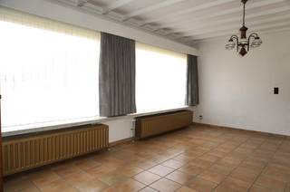 Deze open bebouwing uit 1970 is rustig gelegen en biedt een aangename combinatie van ruimte, comfort en praktische bergruimte. Dankzij de vlotte verbinding met de oprit van de E313 is de woning bovendien ideaal gelegen voor wie rustig wil wonen met een goede bereikbaarheid.<br /><br />De woning beschikt over een bruikbare vloeroppervlakte van 165 m², volgens het EPC, en biedt een functionele indeling met drie slaapkamers, een ruime tuin en een losstaande garage.<br /><br /><strong>Indeling gelijkvloers</strong><br /><br />Via de inkomhal bereikt u de gezellige leefruimte met haard, die aansluit op de keuken. Verder bevindt zich op het gelijkvloers een slaapkamer met airconditioning, een badkamer met ligbad en badkamermeubel, een apart toilet en een praktische wasplaats/berging.<br /><br />De inpandige garage werd omgevormd tot extra bergruimte, wat zorgt voor bijkomende opslagmogelijkheden. Daarnaast beschikt de woning over een afzonderlijke, losstaande garage.<br /><br /><strong>Indeling eerste verdieping</strong><br /><br />De nachthal is voorzien van ingebouwde kasten en geeft toegang tot twee slaapkamers, waarvan één uitgerust is met inbouwkasten. Verder is er een zolderruimte die extra opbergmogelijkheden biedt.<br /><br /><strong>Comfort en uitrusting</strong>
<ul>
<li>Verwarming op aardgas via een condenserende gasketel</li>
<li>Houten ramen met dubbele beglazing</li>
<li>Rolluiken aan alle ramen</li>
<li>Elektrische rolluiken aan de voorgevel, handmatige bediening aan de overige ramen</li>
<li>Airconditioning in de slaapkamer op het gelijkvloers</li>
<li>Inpandige garage omgevormd tot bergruimte</li>
<li>Losstaande garage</li>
<li>Ruime tuin</li>
</ul>
<strong>Rustig wonen met een vlotte bereikbaarheid</strong><br /><br />De woning is gelegen in een rustige woonomgeving, waar u kunt genieten van de ruimte en het groen rondom de woning. Tegelijk bevindt de oprit van de E313 zich op korte afstand, waardoor omliggende gemeenten en belangrijke verbindingswegen vlot bereikbaar zijn.<br /><br />Met haar drie slaapkamers, ruime tuin, praktische bergruimtes en losstaande garage vormt deze woning een interessante opportuniteit voor wie op zoek is naar een ruime gezinswoning met tal van mogelijkheden.<br /><br /><strong>Bruikbare vloeroppervlakte: 165 m² volgens het EPC.</strong><br /><br />Interesse? Contacteer ons gerust voor meer informatie of een bezoek ter plaatse.