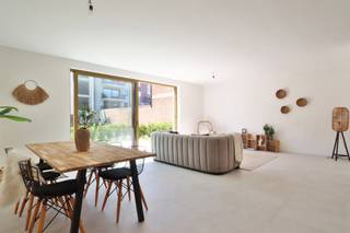 Dit <strong>gelijkvloers nieuwbouwappartement</strong>, recent opgeleverd binnen het BEN-project “<em>Het Perron</em>”, combineert comfortabel wonen met een uitstekende ligging aan het station, de fietsostrade en op wandelafstand van het centrum van Beveren.<br /><br />Het appartement beschikt over een <strong>bewoonbare oppervlakte van 105,25 m²</strong> en omvat <strong>twee slaapkamers</strong>. De aangename leefruimte geeft uit op het <strong>ruime zuidwest georiënteerde terras van 13,6 m²</strong>, dat <strong>afgebakend is met een haagje</strong>, waardoor u in alle privacy kan genieten van het buitenleven. De terrassen en tuintjes van de gelijkvloerse appartementen zijn bovendien gelegen in een grote, afgesloten gemeenschappelijke tuin, wat zorgt voor een groene, rustige en veilige woonomgeving.<br /><br />De <strong>keuken kan nog volledig naar eigen smaak en budget gekozen worden</strong>. <strong>Bovenop het bestaande keukenbudget geniet u bovendien van een extra keukenbudget ter waarde van € 5.000</strong>, waardoor u nog meer vrijheid heeft om uw droomkeuken samen te stellen.<br /><br />Op technisch vlak is het appartement uitgerust met <strong>vloerverwarming</strong>, een <strong>energiezuinige warmtepomp</strong>, <strong>zonnepanelen</strong> en een <strong>ventilatiesysteem type D</strong>, wat garant staat voor een aangenaam binnenklimaat, een laag energieverbruik en maximaal wooncomfort.<br /><br />Dankzij het <strong>BEN-label (E-peil max. E10)</strong> woont u hier bijzonder energiezuinig en toekomstgericht. Dit vertaalt zich niet alleen in lagere energiekosten, maar ook in <strong>financiële voordelen</strong>, zoals <strong>100% korting op de onroerende voorheffing gedurende 5 jaar</strong>.<br /><br />Daarnaast beschikt het project over een <strong>volledige ondergrondse parking</strong>, rechtstreeks toegankelijk vanuit het gebouw, met <strong>autostaanplaatsen, kelderbergingen en fietsenstallingen</strong>.<br /><br />Dit appartement komt bovendien in aanmerking voor de <strong>6% BTW*-regeling voor eigen bewoning</strong>.<br />Ook is het een interessante opportuniteit met <strong>6% BTW* voor investeerders</strong>! Geniet van een verlaagd BTW-tarief mits <strong>15 jaar verhuur</strong>, wat zorgt voor een lagere instap en een aantrekkelijk rendement op lange termijn.<br />(*mits voldaan wordt aan de wettelijke voorwaarden)<br /><br />Bent u op zoek naar een instapklaar, energiezuinig gelijkvloers appartement met 2 slaapkamers, een privatief terras, moderne technieken en een groene gemeenschappelijke tuin op een topligging?<br />Graag laten we u dit appartement persoonlijk ontdekken. Neem gerust contact met ons op voor bijkomende informatie of een bezoek via verkoop@homevast.be of tel. 03 344 77 44.