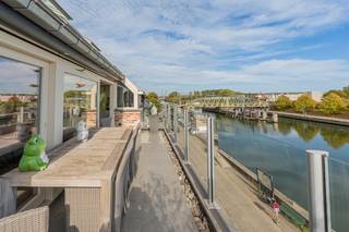 <p>Op zoek naar een high-end, instapklare penthouse op een rustige, maar centrale locatie? Dit appartement aan het water biedt een mooie combinatie van comfort en locatie.</p><p>Via de privatieve inkomhal komt u in de de zeer ruime (50m²!) en lichtrijke woonkamer met grote raampartijen en sublieme gashaard die voor extra gezelligheid zorgt in de koude wintermaanden. De volledig geïnstalleerde, open keuken met eiland is een waar genot voor zowel dagdagelijks gebruik als een leuke avond met gezelschap. Vanuit de zithoek, eetkamer en keuken geniet je op elk moment van het jaar van een open zicht op het water. Het appartement geniet van 2 ruime terrassen: 11m² aan de voorzijde met zicht op het water waar je geniet van de ochtendzon en de gehele namiddag en avond geniet je van de zon op het riant terras aan de achterzijde van meer dan 50m². Verder beschikt het appartement nog over een bergruimte en gastentoilet, alsook over twee ruime slaapkamers, elks voorzien van maatkasten. De master bedroom sluit aan op de ensuite badkamer met ruime inloopdouche, dubbele lavabo, toilet en ook hier maatkasten. Bovendien geniet het appartement van 6 privatieve zonnepanelen, wat bedraagt aan energielabel A. </p><p>Geen dagdagelijkse parkeerproblematiek dankzij de privatieve garagebox en ook opslagplaats kom je niet tekort dankzij de kelderberging.</p><p>De ligging is uitstekend: centraal in Willebroek, op wandelafstand van winkels, horeca en openbaar vervoer, en ideaal voor wandel- en fietstochten langs het water.</p><p>Stedenbouwkundige inlichtingen: aangevraagd</p>
