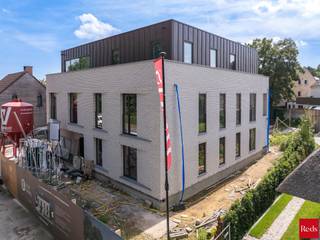 Exclusief woonproject in het centrum van Zandhoven:<br /><br />Voor wie ruim en luxueus wil wonen in de dorpskern, bieden wij dit nieuwbouwproject, Residentie Bruyneel, aan. Deze residentie combineert moderne luxe met functioneel design. Gelegen in het pittoreske Zandhoven, biedt dit project exclusieve woongelegenheid met hoogwaardige afwerking.<br /><br />Deze stijlvolle residentie telt 4 ruime luxe-appartementen en 1 exclusief dakappartement, telkens met een ruim zuid-gericht terras. De appartementen op het gelijkvloers hebben bovendien een mooie privatieve tuin. Achteraan het perceel zijn ruime privatieve autostaanplaatsen (2 per appartement waarvan 1 overdekt). Daar is ook een gemeenschappelijke fietsenberging voorzien. Ondergronds zijn er privatieve kelders. De aankoop van de autostaanplaatsen en een kelder is verplicht bij de aankoop van een appartement. <br /><br />Dit project is een realisatie van Struyf Building van Zandhoven, een gekend bedrijf die in de regio tal van referenties kan voorleggen. Het ontwerp is van de hand van architectenbureau Studio Noord, die andermaal voor een doordachte en stijlvolle architectuur hebben gezorgd. Elk appartement heeft ruime afwerkingsbudgetten en is uiteraard energiezuinig dmv het gebruik van een lucht-water warmtepomp, in combinatie met zonnepanelen. Het E-peil van deze appartementen ligt onder 20! <br /><br />De verkoop geschiedt onder BTW op de constructies (aankoop aan 6% BTW mogelijk, vraag naar de voorwaarden) en registratierechten op grondaandeel. Geen voorafgaande betalingen-volledige betaling bij oplevering van het appartement! Voor meer info of een verkennend gesprek, contacteer Karin 0486/97 84 27 of karin@reds.be.