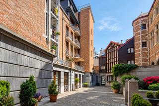 Nog voor u het appartement zelf bereikt, laat dit gebouw al een indruk na. Achter de karaktervolle gevel ontvouwt zich een authentiek geheel waarin de oorspronkelijke sfeer mooi bewaard bleef: van de charmante toegangsgang met houten brievenbussen tot de sfeervolle binnenkoer en gemeenschappelijke delen. Het appartement op de derde verdieping biedt op zijn beurt een aangename basis en veel potentieel om verder naar eigen smaak vorm te geven.<br /><br />Ook de ligging past perfect in dat verhaal. De Zwartzustersstraat bevindt zich midden<strong> in het historische hart van Antwerpen</strong>, op een steenworp van de Sint-Pauluskerk en op wandelafstand van de Grote Markt, de Scheldekaaien, winkels en horeca. Ook de Meir en het Eilandje zijn vlot te voet bereikbaar, waardoor cultuur, gastronomie, winkelen en het dagelijkse stadsleven hier letterlijk om de hoek liggen.<br /><br /><strong>Indeling</strong><br />Via de authentieke doorgang met originele houten brievenbussen bereikt u de charmante binnenkoer van het gebouw. De binnenplaats is eveneens toegankelijk via een afzonderlijke zijingang met automatische poort voor wagens, die verder leidt naar de ondergrondse parking. Een bijkomende trap biedt vanuit de binnenkoer rechtstreeks toegang tot het ondergrondse niveau.<br /><br />Vanuit de binnenplaats bereikt u de inkomhal van het appartementsgebouw, waar opnieuw verschillende karaktervolle elementen terugkomen. Het appartement bevindt zich op de derde verdieping en is zowel met de lift als via de traphal bereikbaar.<br /><br />Binnen leidt de inkomhal met vestiairegedeelte en gastentoilet naar de lichtrijke woon- en eetkamer. Aansluitend bevindt zich de halfopen keuken met praktische berging.<br /><br />Vanuit de woonkamer heeft u toegang tot een gezellig terras van ca. 7 m², een fijne buitenruimte midden in de stad.<br />Verder geeft de woonkamer toegang tot twee slaapkamers. Tussen beide kamers bevindt zich de badkamer, uitgerust met douche in bad, dubbele lavabo en toilet.<br />Tot slot beschikt het appartement over een private kelderberging. Een ondergrondse <strong>autostaanplaats kan optioneel worden aangekocht voor € 35.000</strong>.<br /><br /><strong>Bijzonderheden</strong><br />Een appartement met EPC C en veel potentieel, gelegen in een uitzonderlijk karaktervol gebouw waar authentieke elementen, een charmante binnenkoer en hedendaags gemak zoals een lift en ondergrondse parking mooi samenkomen.<br />Een interessante plek voor wie centraal in Antwerpen wil wonen en tegelijk waarde hecht aan architectuur, authenticiteit en een appartement dat nog naar eigen smaak kan evolueren.
