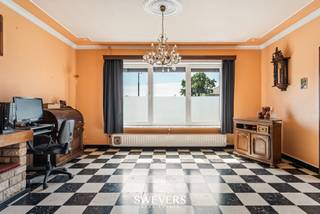 Voor meer info en foto’s, surf naar www.swevers.be – Deze halfopen bebouwing aan de Dorpsstraat 47 in Nieuwerkerken biedt een stevige basis voor wie een woning volledig naar eigen smaak wil afwerken. De woning, gebouwd in 1967, beschikt over een bewoonbare oppervlakte van 144 m², drie volwaardige slaapkamers en ligt op een perceel van 7a 08ca. Doorheen de jaren werden al belangrijke renovaties uitgevoerd: nieuwe ramen (2013), een vernieuwde badkamer en verwarmingsketel (2016), dakherstelling en een nieuwe keukenvloer (2024). Via de inkomhal bereikt u de gezellige leefruimte, aansluitend aan de ruime keuken met voldoende plaats voor een moderne inrichting. Achteraan bevinden zich een apart toilet en de technische ruimte. Op de eerste verdieping geven de nachthal, drie comfortabele slaapkamers en de vernieuwde badkamer een praktische indeling voor een gezin. Buiten beschikt u over een aparte berging met wasplaats, ideaal als extra opslagruimte. De noordwestelijk georiënteerde tuin biedt een aangename combinatie van zon en schaduw en vormt een fijne plek om te ontspannen, te tuinieren of gezellig samen te komen. De woning is rustig gelegen in Nieuwerkerken, met een vlotte verbinding naar omliggende steden dankzij de snelweg op ongeveer 8,5 km. Ook openbaar vervoer bevindt zich op een praktische afstand. Deze woning is een interessante kans voor wie op zoek is naar ruimte, een praktische indeling en heel wat mogelijkheden om verder te moderniseren. Voor meer informatie, bel 012 699 900. Bron bewoonbare oppervlakte: EPC – verslag. Dit pand is onderworpen aan de renovatieverplichting van de Vlaamse overheid voor residentiële gebouwen (behoudens bij sloop binnen 5 jaar na de aankoop). Consulteer voor meer informatie de website van het Vlaams Energie- en Klimaatagentschap via https://www.vlaanderen.be/een-huis-of-appartement-kopen/renovatieverplichting-voor-residentiele-gebouwen.