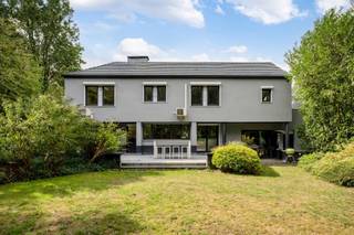 <p><span>Ruime op te frissen woning met 4 slaapkamers, wellness, dubbele garage en tal van mogelijkheden!</span></p><p><span> </span></p><p><span>Deze bijzonder ruime woning combineert een royale bewoonbare oppervlakte met tal van mogelijkheden en een uitstekende bereikbaarheid. De woning is momenteel ingericht als</span></p><p><span>kantoorruimte, maar beschikt over een volwaardige residentiële indeling en kan opnieuw worden ingericht tot een comfortabele gezinswoning.</span></p><p><span> </span></p><p><span>Op het gelijkvloers bevindt zich een ruime inkomhal met gastentoilet. Aan de linkerzijde vinden we een afzonderlijke bureauruimte, ideaal als thuiskantoor of praktijkruimte.</span></p><p><span>De royale leefruimte biedt plaats aan zowel een ruime eetplaats als een aparte, gezellige zithoek met gashaard alsook een TV-ruimte.</span></p><p><span>Grote raampartijen zorgen voor veel natuurlijk licht en zijn op het gelijkvloers voorzien van zonneluifels. De woning is hoofdzakelijk afgewerkt met tegelvloeren en beschikt over in de vloer geïntegreerde convectoren.</span></p><p><span>De zeer ruime keuken biedt veel werk- en bergruimte en geeft via de achterdeur rechtstreeks toegang tot het terras en de tuin. Aansluitend bevinden zich nog een praktische berging en bijkeuken.</span></p><p><span>Een absolute troef is de grote polyvalente ruimte, momenteel ingericht met een bar. Onder de huidige vloer bevindt zich het oorspronkelijke binnenzwembad. De vloerconstructie kan opnieuw worden verwijderd, waardoor het zwembad opnieuw in gebruik kan worden genomen en hier een prachtige ontspanningsruimte kan worden gecreëerd. Aansluitend bevindt zich een aparte wellnessruimte met stoomcabine en sanitair.</span></p><p><span> </span></p><p><span>Op de verdieping bevinden zich vier volwaardige slaapkamers. De master bedroom beschikt over ingebouwde kasten. Eén van de slaapkamers heeft een eigen douchekamer. Daarnaast is er een ruime badkamer met ligbad, douche, lavabo en toilet. Ook de verdieping is hoofdzakelijk voorzien van tegelvloeren.</span></p><p><span> </span></p><p><span>Ook aan praktische ruimte is er geen gebrek. De woning beschikt over een zeer ruime, volledig betegelde kelder en een dubbele inpandige garage, rechtstreeks bereikbaar via de oprit.</span></p><p><span> </span></p><p><span>Voor extra comfort is zowel op het gelijkvloers als op de verdieping airconditioning aanwezig. Daarnaast beschikt de woning over een alarmsysteem, een gashaard en werd de verwarmingsinstallatie ongeveer vier jaar geleden vernieuwd.</span></p><p><span>Ook energetisch is er een belangrijke troef: de woning heeft een EPC-score van C, waardoor er geen renovatieverplichting van toepassing is.</span></p><p><span> </span></p><p><span>Buiten valt meteen de uitzonderlijk ruime parking aan de voorzijde op, met plaats voor meerdere wagens. Achteraan geniet u van een mooi terras en een ruime, groene tuin. De achterliggende groene omgeving zorgt bovendien voor een aangenaam en open karakter.</span></p><p><span> </span></p><p><span>De woning kan op bepaalde punten naar eigen smaak worden opgefrist, maar biedt dankzij haar uitzonderlijke ruimtes, vier slaapkamers, binnenzwembad en wellnessmogelijkheden, dubbele garage en ruime buitenomgeving bijzonder veel potentieel. Ook voor wie wonen en werken wil combineren, biedt dit pand interessante mogelijkheden.</span></p><p><span> </span></p><p><span>Troeven:</span></p><p><span> - EPC-score C  geen renovatieverplichting</span></p><p><span> - 4 slaapkamers</span></p><p><span> - Zeer ruime leefruimtes</span></p><p><span> - Grote keuken met aansluitende berging en bijkeuken</span></p><p><span> - Binnenzwembad aanwezig onder de huidige vloer</span></p><p><span> - Wellnessruimte met stoomcabine</span></p><p><span> - Airconditioning op gelijkvloers en verdieping</span></p><p><span>- Gashaard</span></p><p><span> - Vloerconvectoren</span></p><p><span>- Verwarmingsinstallatie ca. 4 jaar geleden vernieuwd</span></p><p><span>- Grote, volledig betegelde kelder</span></p><p><span> - Dubbele inpandige garage</span></p><p><span>- Uitzonderlijk ruime parking vooraan</span></p><p><span> - Mooi terras en groene tuin</span></p><p><span>- Achterliggende groene omgeving</span></p><p><span>- Alarmsysteem</span></p><p><span> - Interessant voor combinatie wonen en werken</span></p><p><span> - Goede bereikbaarheid</span></p>