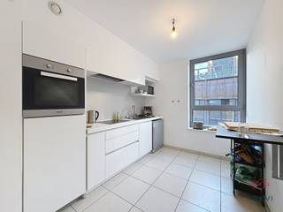 BRUSSELS, Niuwestraat. In een modern woonblok, mooi appartement van +/-105m² (cfr PEB) bestaande uit een inkomhal met apart toilet, een grote woonkamer van ±40m² (salon en eetkamer) die uitgeeft op een terras, een superuitgeruste open keuken, twee slaapkamers, badkamer en douche. Een kelder is inbegrepen in de prijs. Nutsvoorzieningen: forfait van 95€/maand voor gemeenschappelijke ruimtes + voorziening voor verwarming en warm water voor 95€/maand. Beschikbaar 01/02/2026 ! RGP: C - 25kg CO2/(m².an). Onze advertenties zijn niet contractueel bindend. 