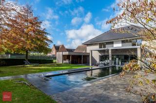 De woning omvat een inkomhal, een ruime leefruimte met gashaard, een bureauruimte, een gezellige bar, een volledig ingerichte leefkeuken,...