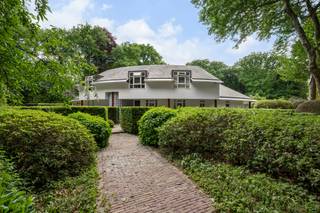 Architecturale villa in het groen, op een toplocatie in Heide<br /><br />Karaktervolle architectuur, royale leefruimtes, lichtinval en een oase van groen. Deze bijzondere villa in Heide combineert een uitgesproken architecturale uitstraling met een uitzonderlijk rustige ligging en een prachtige, volwassen tuin. En dat op behapbare afstand van het centrum, het treinstation, winkels en scholen én sportfaciliteiten.<br /><br />De woning valt meteen op door haar krachtige vorm, grote raampartijen en strakke tijdloze architectuur. Licht en ruimte spelen de hoofdrol, terwijl de leefruimtes op een natuurlijke manier in verbinding staan met de tuin. <br />Een woning met karakter, waar architectuur en natuur elkaar versterken.<br /><br />Rondom de villa ontvouwt zich een fraai aangelegde tuin met open ruimte, volwassen bomen, groene hagen en ruim terras. Hier geniet je in alle rust van het buitenleven, met volop privacy en het groen als decor.<br /><br />Gelijkvloers — ruimte, licht en connectie met de tuin<br />Via de inkomhal met vestiaire en gastentoilet kom je binnen in een woning waar ruimte en functionaliteit hand in hand gaan.<br />Ruim bureau met ingemaakte kasten en een aangenaam zicht op de tuin. Ideaal als thuiswerkplek of creatieve ruimte.<br />Lichtrijke leefruimte met parketvloer en een aparte, gezellige leeshoek. De grote raampartijen brengen het groen naar binnen en zorgen voor een directe verbinding met het zonnige terras.<br />Volledig ingerichte Bulthaup keuken (2009), royaal opgevat en uitgerust met kwalitatieve toestellen: een grote Miele-inductiekookplaat, oven, combi-oven, ingebouwde Miele-koffiemachine, vaatwasser, koelkast en diepvriezer.<br />Praktische bijkeuken met ingemaakte kasten en aansluitingen voor wasmachine en droogkast.<br /><br />Dubbele garage met automatische poort, met aansluitend toegang tot het overdekte terras.<br /><br />Kelderverdieping — extra ruimte en praktisch comfort<br />De ruime kelderverdieping biedt heel wat mogelijkheden en extra bergruimte. <br />Je vindt er verschillende stockageruimtes, een technische ruimte met de boiler, ingemaakte kasten en een aparte wijnkelder.<br /><br />Verdieping — vier slaapkamers en twee badkamers<br />Op de verdieping bevindt zich de master bedroom, een royale slaapkamer met dressing en rechtstreekse toegang tot het zonnige terras. <br />De aansluitende badkamer is uitgerust met een sauna, douche, toilet en dubbele lavabo.<br />Daarnaast zijn er drie volwaardige extra slaapkamers, waarvan één beschikt over bijkomende bergruimte achteraan. <br />Een tweede badkamer met douche en dubbele lavabo en een apart toilet vervolledigen deze verdieping.<br /><br />De tuin — groen, privacy en buitenleven<br />De tuin is zonder twijfel een van de grote troeven van deze woning. Het ruime gazon, de volwassen bomen en de groene hagen creëren een sfeervolle, beschutte omgeving waar rust en privacy centraal staan.<br />De zonnige terrassen bieden verschillende plekken om te genieten van lange zomeravonden of een rustig moment buiten. Een charmante siervijver en een praktisch tuinhuis maken het geheel compleet.<br /><br />Buitengewone kenmerken<br /><br />13 zonnepanelen, ongeveer 3 à 4 jaar oud<br />Thuisbatterij<br />Laadpaal voor een elektrische wagen<br />Dubbele garage met automatische poort<br />Zonnig overdekt terras<br />Fraai aangelegde tuin met volwassen groen en veel privacy<br />Alarmsysteem<br /><br />Mogelijkheid om het EPC-label te verbeteren: volgens de opgegeven informatie zou een lucht-luchtwarmtepomp (gecombineerd met de reeds aanwezige zonnepanelen en thuisbatterij) in de living, eetkamer en tv-hoek, met een COP van 4,0, kunnen bijdragen aan het behalen van een gunstiger EPC-label. <br /><br />Een architecturale villa voor wie houdt van karakter, licht en ruimte, met het comfort van vandaag en de rust van een groene omgeving. Een bijzonder aangename plek om thuis te komen, midden in Heide.