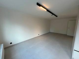 À louer dans la résidence Christine à Ostende : un appartement entièrement rénové et prêt à emménager, proposé à la location pour la première fois. L'appartement est disponible immédiatement et tous les appareils et équipements sont flambant neufs et n'ont jamais été utilisés. En entrant, vous disposez d’un hall d’entrée spacieux équipé d’un interphone, qui donne accès à un grand salon particulièrement lumineux. La cuisine ouverte s’intègre harmonieusement à l’espace de vie et est équipée d’un réfrigérateur encastré, d’une plaque de cuisson électrique et d’une hotte aspirante. Un espace a également été prévu pour l’installation d’un lave-vaisselle ou d’un lave-linge, selon votre choix. L'appartement dispose de deux chambres, dont une chambre principale spacieuse et une chambre plus petite qui peut également servir de bureau, de dressing ou de chambre d'enfant. À l'arrière de l'appartement se trouve une terrasse. La salle de bains entièrement rénovée est équipée d'une douche, d'un lavabo, de toilettes et de nouveaux équipements sanitaires. L'appartement est chauffé au gaz et dispose d'un thermostat. L'immeuble est équipé d'un ascenseur et d'un interphone, et tous les compteurs sont individuels. Le garage, inclus dans le loyer, constitue un atout majeur. Depuis le garage, on accède directement à l'immeuble et à l'appartement, ce qui est particulièrement pratique. Il n'y a pas de local à vélos ni de cave séparés, mais le garage peut bien sûr être utilisé à cette fin.L'emplacement constitue également un atout majeur : le centre d'Ostende est facilement accessible à vélo, tout en bénéficiant d'un accès rapide aux principales voies d'accès et à l'autoroute. L'appartement est disponible au loyer de 895 € par mois, auquel s'ajoute une provision de 75 € par mois pour les charges communes. Le coût mensuel total s'élève donc à 970 €, hors charges individuelles. Un logement idéal pour ceux qui recherchent un appartement entièrement rénové, confortable et disponible immédiatement, avec un box de garage, dans un emplacement facilement accessible à Ostende.