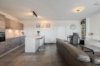 Ruim 2-slaapkamerappartement met zonneterras en eigen autostaanplaats<br /><br />Op zoek naar een ruim en comfortabel appartement op een centrale ligging? Ontdek dit aangename appartement in residentie Amina, waar ruimte en praktisch wooncomfort mooi samengaan.<br /><br />De lichtrijke leefruimte met open, volledig ingerichte keuken vormt het hart van het appartement en sluit aan op het zonneterras. Verder beschikt het appartement over twee volwaardige slaapkamers, een badkamer en een inkomhal.<br /><br />Ook aan praktisch gemak geen gebrek: er is een gemeenschappelijke fietsenberging aanwezig en achteraan het gebouw bevindt zich een autostaanplaats die inbegrepen is in de verkoopprijs.<br /><br />Een mooie opportuniteit voor wie comfortabel wil wonen op een centrale locatie, of op zoek is naar een interessante investering!<br /><br />Meer info / bezoek : 0477 03 03 03