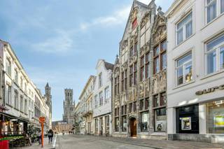 Achter de karaktervolle gevel van dit bijzonder pand in de Vlamingstraat, op een steenworp van de Grote Markt en het Belfort, schuilt een verrassende royale oppervlakte.<br />Met maar liefst ongeveer 260m² commerciële ruimte op het gelijkvloers en ongeveer 500m² bruikbare residentiële ruimte op de bovenverdiepingen biedt dit vastgoed een zeldzame waaier aan ontwikkelings- en investeringsmogelijkheden.<br /><br />Indeling:<br />- Gelijkvloers: handelsgelijkvloers (260m²) leegstaand (momenteel in gebruik als opslagruimte) - verschillende lokale en bergingen (keuken, badkamer, toilet..), terras<br />- Kelder (220m²) is onderverdeeld in verschillende ruimtes.<br />- Tussenverdieping : Opslagruimte vooraan (54m²)<br />- Eerste verdieping (185m²) : Woonst bestaande uit voorhuis ingedeeld in overloop, badkamer, woonkamer ingedeeld in eet- en zithoek, keuken.<br />Achterhuis ingedeeld in nachthal, 5 slaapkamers, dakterras<br />- Tweede verdieping (185m²): Voorhuis ingedeeld in 3 kamers, achterhuis ingedeeld in nachthal, toilet en 4 slaapkamers.<br />- 3 zolders (125m²) met vaste trap<br /><br />Mogelijkheid om dubbele garage aan te kopen.<br /><br />Investeringspotentieel & Troeven<br />Dankzij het indrukwekkende bouwvolume en de flexibele indeling leent deze eigendom zich perfect voor diverse invullingen. De unieke symbiose van een ruim handelsgelijkvloers en een royaal woonvolume maakt het pand uiterst aantrekkelijk voor:<br /><br />Ondernemers & vrije Beroepen: Combineer uw winkel, showroom, kantoor of praktijk op de begane grond met zeer ruim comfortabel wonen op de verdiepingen.<br /><br />Investeerders & ontwikkelaars: Strategisch gelegen opbrengsteigendom met potentieel voor herontwikkeling of meerwoonstproject (mits het bekomen van de nodige vergunningen).<br /><br />De eigendom wordt aangeboden via de Pre-sale formule. Van 16/10/2026 om 09:00 tot 04/12/2026 om 16:00 kan u het handelspand op afspraak komen bezichtigen en een bod uitbrengen. De vermelde prijs is een instelprijs. Voor meer info, gelieve contact op te nemen met de dossierverantwoordelijke.<br /><br />Bestuursmaatregelen in het maatregelenregister: nee