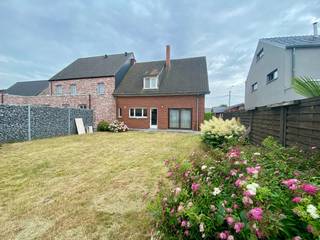 Op een centrale locatie, vlak bij winkels, scholen en andere voorzieningen, bevindt zich deze charmante woning met tal van mogelijkheden. Hoewel er nog opfrissingswerken nodig zijn, vormt de degelijke en klassieke structuur een uitstekende basis voor wie zijn eigen woonwensen wil realiseren.<br /><br />Indeling op het gelijkvloers:<br /><br />- Inkomhal met trap naar de verdieping<br />- Lichtrijke leefruimte met gezellige gashaard<br />- Ruime, aparte eetkeuken uitgerust met dubbele spoelbak, keramische kookplaat, dampkap, oven en koelkast<br />- Inpandige garage voor één wagen met aansluiting voor wasmachine en droogkast<br />- Apart gastentoilet<br />- Droge kelder<br /><br />Op de verdieping bevinden zich vier kamers, waarvan drie volwaardige slaapkamers en één kleinere kamer. Daarnaast is er voldoende ruimte om een dressing te creëren. Centraal gelegen vindt u de badkamer, uitgerust met lavabo, ligbad, bidet en toilet.<br /><br />De zolder is bereikbaar via een zolderluik met uitschuifbare trap en biedt extra bergruimte.<br /><br />Achteraan geniet u van een onderhoudsvriendelijke tuin met rechtstreekse toegang tot het achterliggende fiets- en wandelpad, een absolute meerwaarde voor wie houdt van rust en recreatie.<br /><br />Extra troeven:<br /><br />- Deels PVC-ramen en deels houten ramen met dubbele beglazing<br />- Deels elektrische en deels manuele rolluiken<br />- Centrale verwarming op stookolie (ondergrondse tank van 2.000 liter)<br />- Regenwaterput van circa 5.000 liter<br />- Betongewelven<br />- Vernieuwde schouw<br /><br />Deze woning werd steeds met de grootste zorg onderhouden, wat garant staat voor een solide basis. Een ideale opportuniteit voor wie op zoek is naar een ruime woning die volledig naar eigen smaak kan worden ingericht.<br /><br />De renders van living, keuken en badkamer zijn louter ter illustratie.<br /><br />Interesse? Vraag vandaag nog uw bezoek aan en ontdek het potentieel van deze woning.