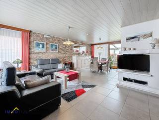 Deze perfect onderhouden halfopen bebouwing verwelkomt u via een inkomhal met vestiaire en gastentoilet. De lichtrijke woonkamer sluit naadloos aan...