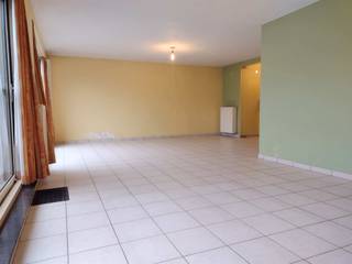 Ruim, lichtrijk, gelijkvloers appartement met groot terras, zuid-west georiënteerd.INDELING:Inkomhal met glazen deuren naar de ruime leefruimte met...