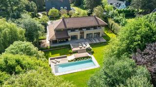 Gelegen in een uiterst rustige laan in het prestigieuze Domein van Bouchout te Wemmel, biedt deze groots opgezette villa hypermodern wooncomfort waar licht en ruimte centraal staan. De strategische ligging garandeert een serene, veilige leefomgeving nabij scholen, invalswegen en de Brusselse Ring.De indrukwekkende inkomhal leidt naar een royaal salon met design-gashaard en plafondhoge ramen, grenzend aan een formele eetkamer. De exclusieve eiken leefkeuken met granieten werkblad is voorzien van een centraal kookeiland, massief houten ontbijtbar en premium inbouwapparatuur (o.a. een rvs Amerikaanse koelkast en stoomoven). Grote schuiframen bieden toegang tot het terras. Aansluitend bevindt zich een praktische wasplaats/bijkeuken die doorsteekt naar de dubbele inpandige garage.Op de eerste verdieping biedt de nachthal toegang tot vier royale slaapkamers. De master suite beschikt over een maatwerk dressing en een luxe badkamer in travertijn natuursteen met ligbad. De overige drie slaapkamers zijn uitgerust met inbouwkasten en worden geflankeerd door twee moderne douchekamers. Een grote, geïsoleerde zolder biedt extra uitbreidingsmogelijkheden.De volledig omsloten loungetuin biedt 100% privacy dankzij de hagen. Centraal ligt het grote, verwarmde buitenzwembad (warmtepomp), omringd door een hardhouten terras en diverse zithoeken. Het perfect georiënteerde terras achteraan biedt een prachtig panorama over het volledige domein.Droomt u ook al weg? Neem dan snel contact op!Bestuursmaatregelen in het maatregelenregister: nee
