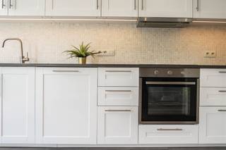 <p>Rustig wonen op wandelafstand van het centrum van Brasschaat, met ruimte, licht en een verzorgde afwerking als rode draad. Dit instapklare appartement op de eerste verdieping biedt 95 m² bewoonbare oppervlakte, twee ruime slaapkamers en een polyvalente derde kamer, een recent vernieuwde keuken en een balkon over de volledige breedte aan de achterzijde. Ook de garagebox is inbegrepen in de vraagprijs van € 315.000.</p><p>Binnen valt meteen de aangename ruimtelijkheid op. De leefruimte is royaal opgevat en biedt alle plaats voor een comfortabele zithoek en een volwaardige eettafel. Het vele natuurlijke licht versterkt het open karakter en maakt van deze ruimte het centrale leefpunt van het appartement.</p><p>Aansluitend bevindt zich de recent vernieuwde open keuken. Ze is volledig uitgerust met koelkast, diepvries, oven, vitrokeramische kookplaat, dampkap en vaatwasser en beschikt over heel wat kastruimte. Wie droomt van een keukeneiland, heeft hier bovendien een mooie mogelijkheid: de nodige aansluitingen zijn reeds voorzien, waardoor de keuken later verder naar eigen smaak kan worden uitgewerkt.</p><p>De indeling biedt een interessante flexibiliteit. Er zijn twee ruime slaapkamers, aangevuld met een derde kamer die zich uitstekend leent als extra slaapkamer, bureau of dressing. Zo past het appartement zich moeiteloos aan verschillende woonbehoeften aan. De badkamer is praktisch ingericht met douche, wastafel, toilet en handdoekdroger. Daarnaast is er een afzonderlijke berging voor de wasvoorzieningen, terwijl de ingemaakte kasten in de gang bijkomende opbergruimte creëren.</p><p>Aan de achterzijde loopt het balkon over de volledige breedte van het appartement. De zuidwestelijke oriëntatie en rechtstreekse toegang vanuit de slaapkamers maken deze buitenruimte tot een aangename aanvulling op het interieur.</p><p>Ook technisch presenteert het appartement zich sterk. Met EPC-label B en een energiescore van 120 kWh/m² is er een gunstige energetische basis. De aluminium ramen beschikken over dubbele beglazing en de individuele verwarming gebeurt via een Vaillant-condensatieketel uit 2018. Het dak werd in 2019 vernieuwd en geïsoleerd. De elektrische installatie is conform gekeurd en er is een asbestveilig attest aanwezig. Aparte meters voor water, gas en elektriciteit, een veiligheidsdeur, parlofoon en vliegenramen dragen verder bij aan het dagelijkse comfort.</p><p>De garagebox achteraan is inbegrepen in de verkoopprijs en vormt in deze centrale omgeving een bijzonder praktisch pluspunt. Ook de gemeenschappelijke kosten blijven overzichtelijk met € 180 per kwartaal; binnen de mede-eigendom is bovendien een reservefonds aanwezig.</p><p>Dit appartement overtuigt vooral door zijn evenwicht: 95 m² woonruimte, een lichtrijke leefruimte, een vernieuwde keuken, een flexibele 2- tot 3-slaapkamerindeling, praktische bergruimte en een eigen garage. Een verzorgde woonplek voor wie rustig wil wonen en tegelijk de nabijheid van het centrum van Brasschaat op prijs stelt.</p><p>Te koop voor € 325.000, garage inbegrepen. Interesse? Contacteer Immo LEY via info@immoley.be voor een exclusief bezoek. Bel ons via 03 535 2000.</p>